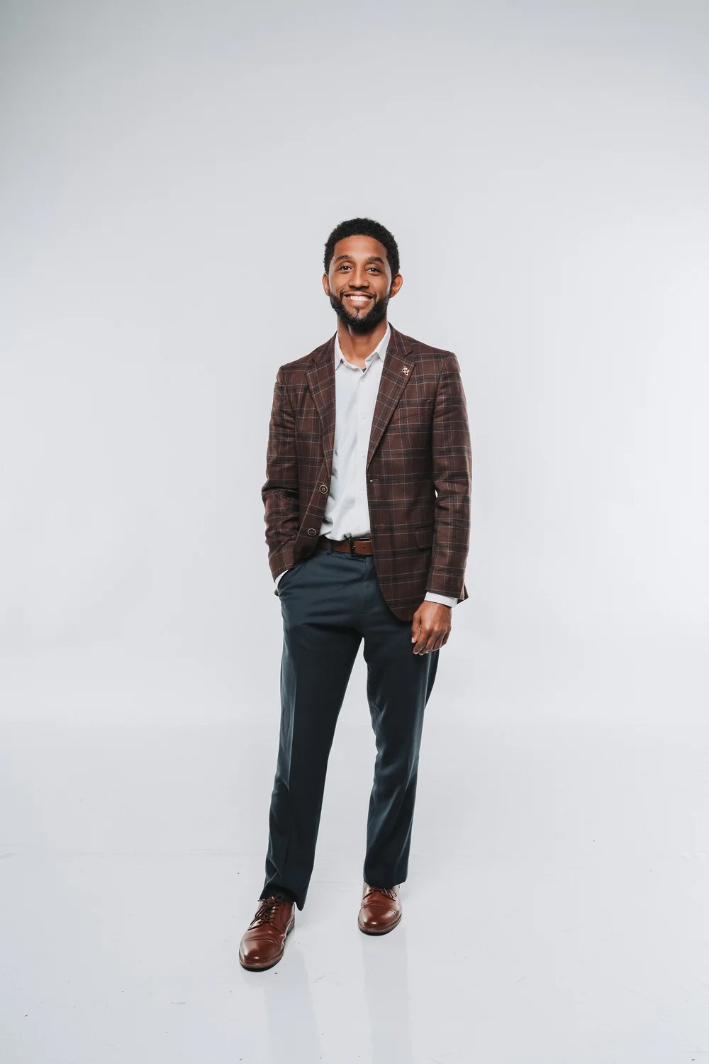 Seated studio portrait of a man in a tailored blazer