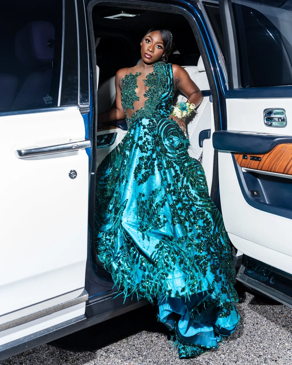 Prom portrait in a teal gown beside a white car