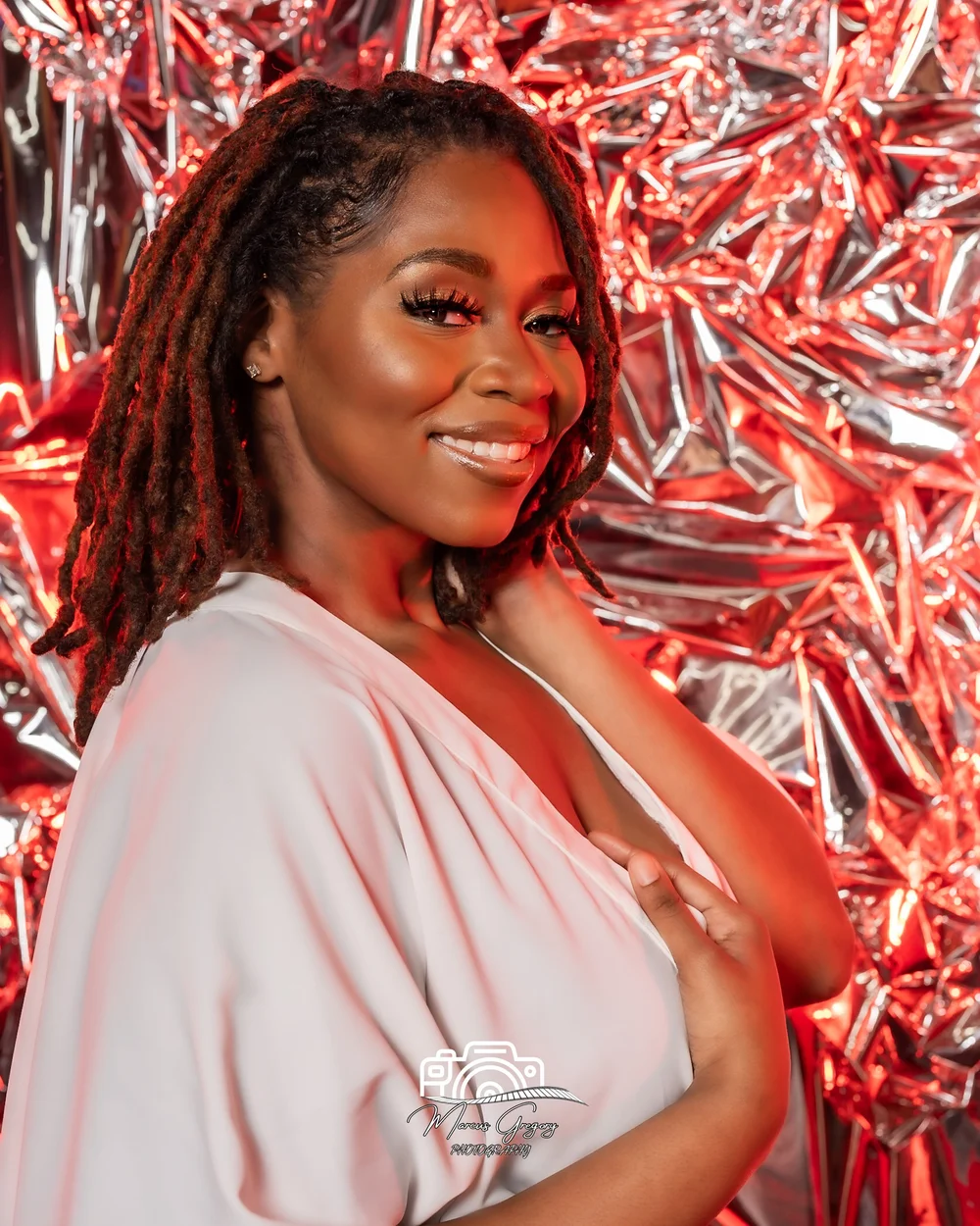 Studio portrait in blush tones on a red backdrop