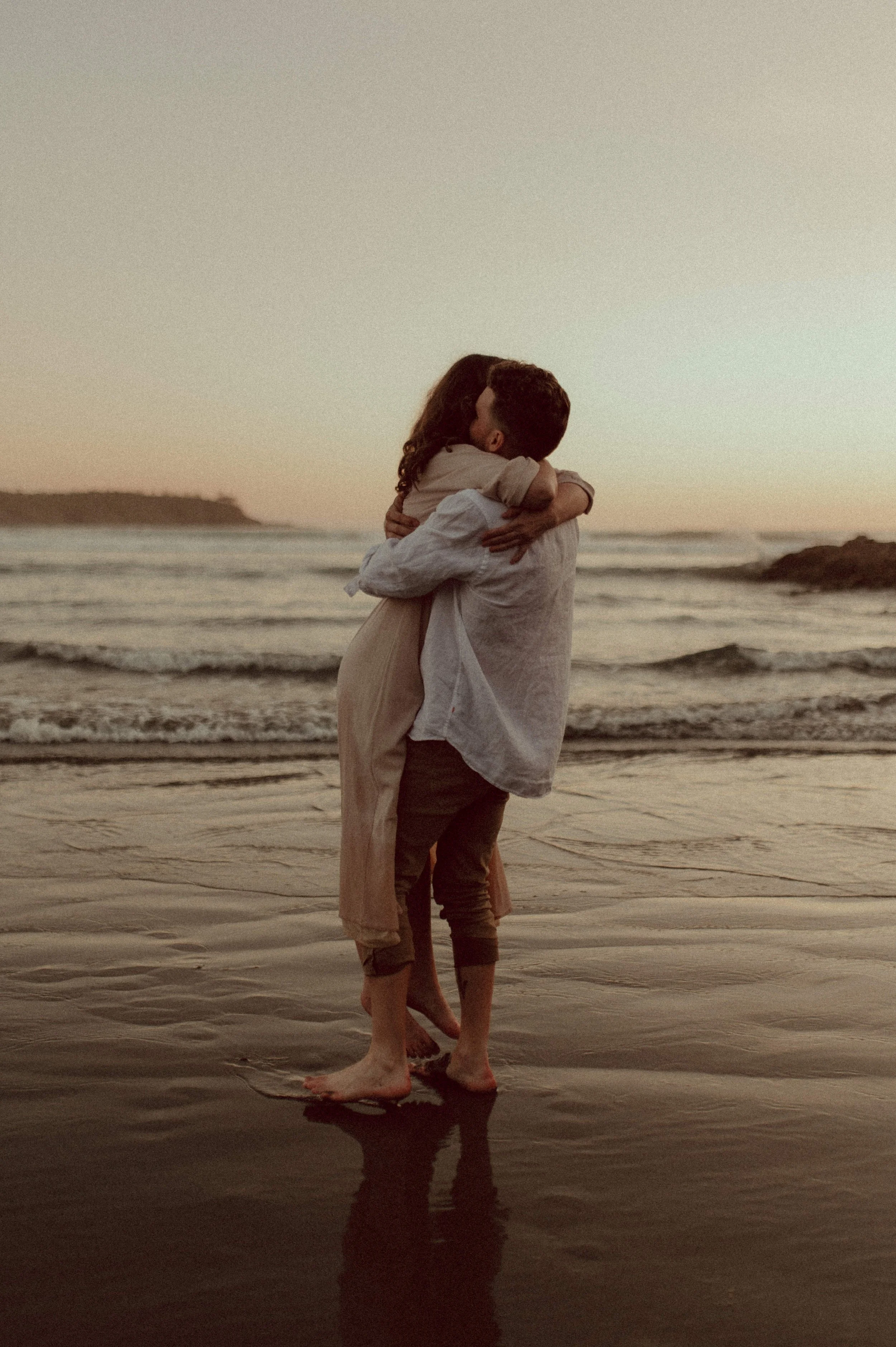 A couple embracing on a beach, engagement photos, Tofino, British Colombia