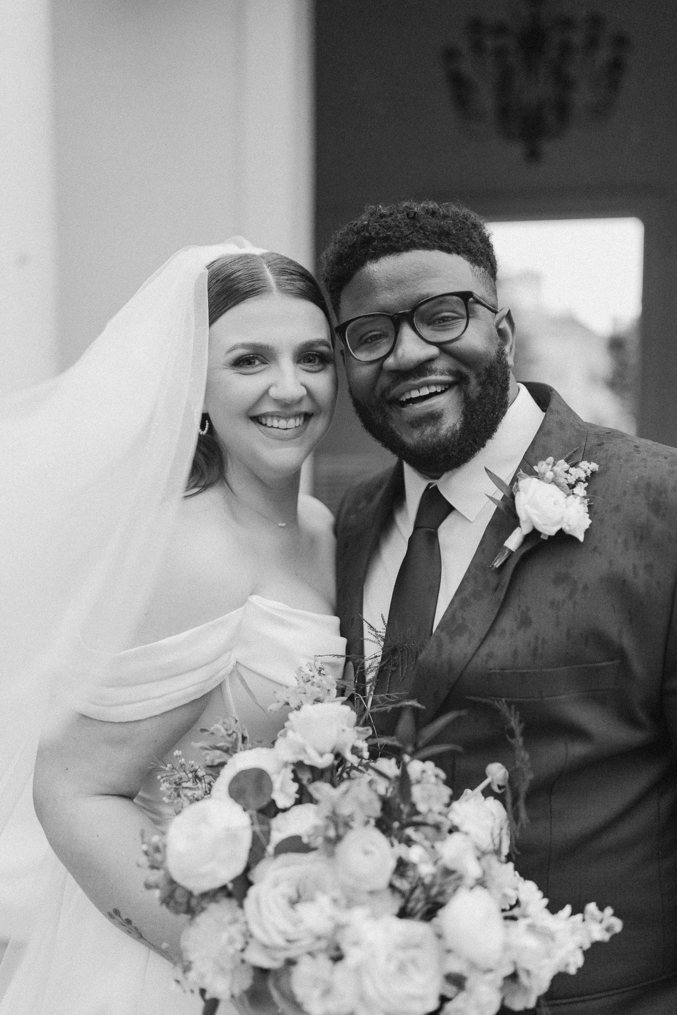 Black-and-white portrait of newlyweds smiling together