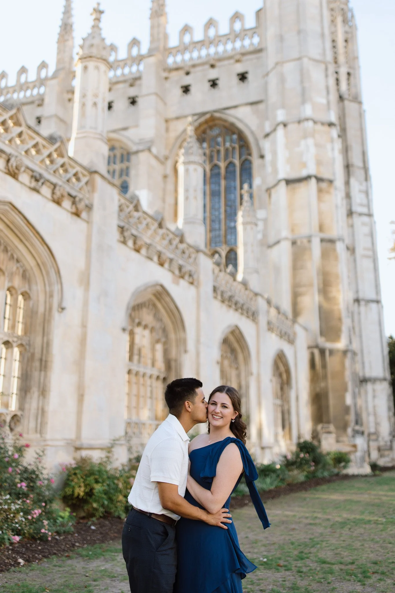 Couple embracing outside historic architecture in Cambridge, UK