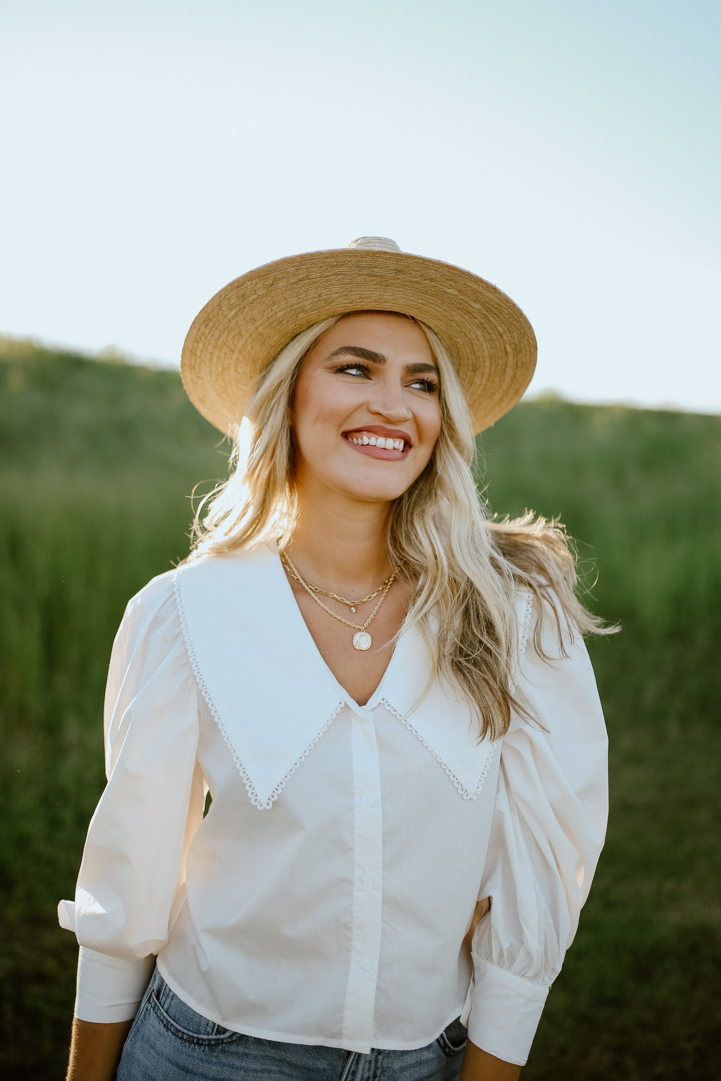 Outdoor portrait of a smiling woman wearing a wide-brimmed hat