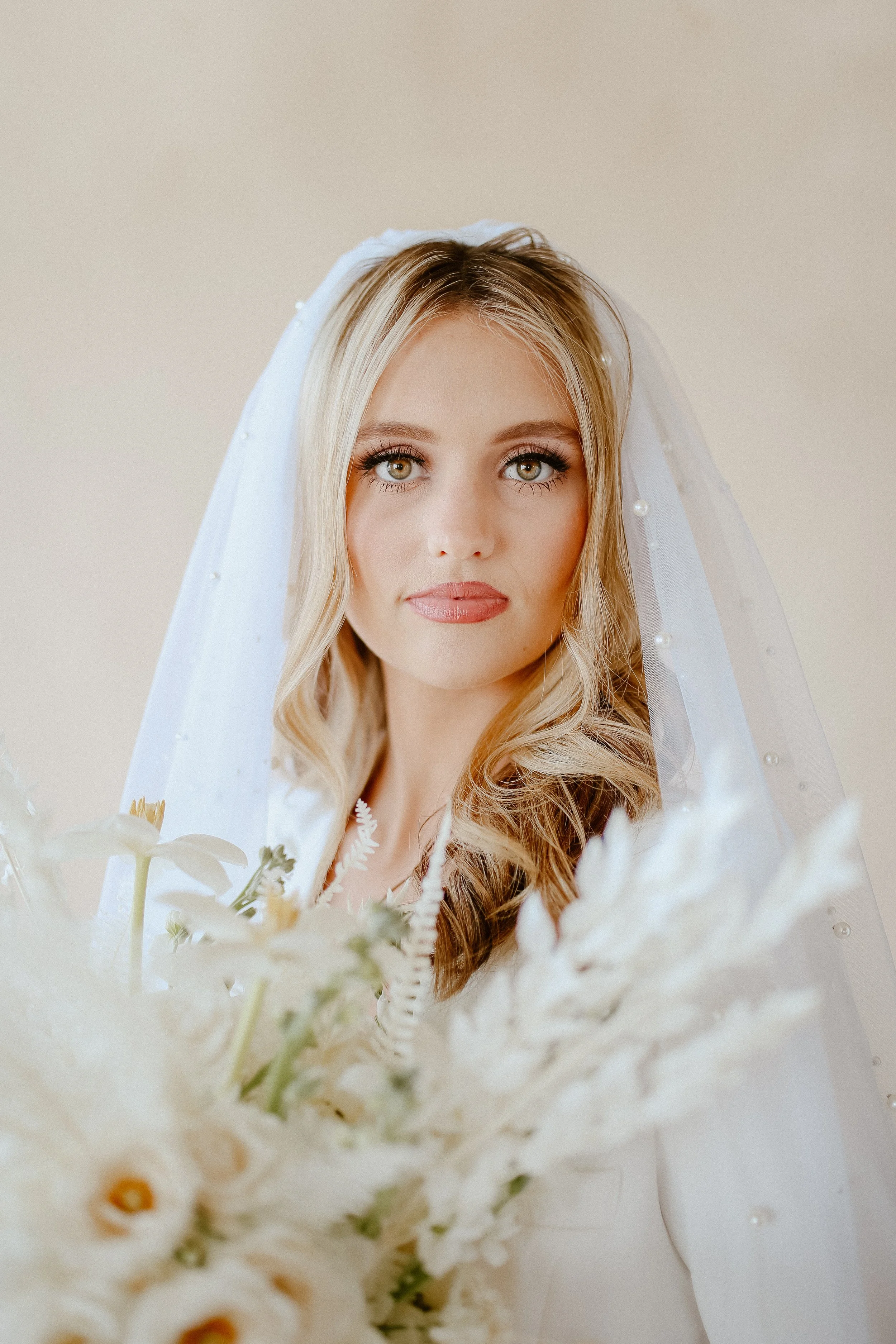 Close-up bridal portrait with veil and white flowers