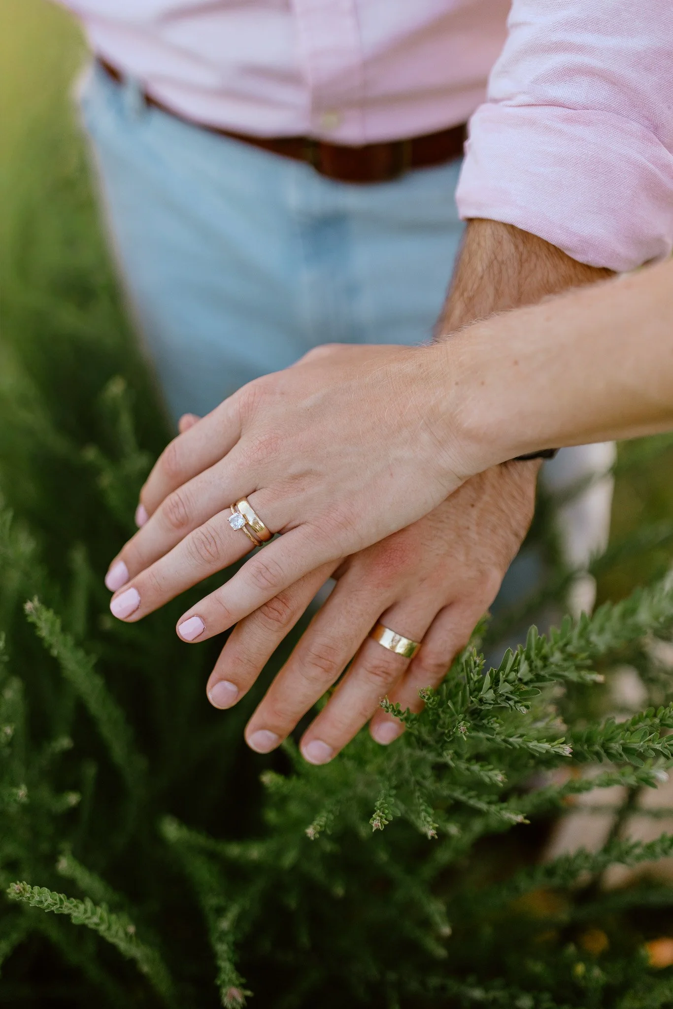 Newlyweds showing their wedding rings during an outdoor portrait