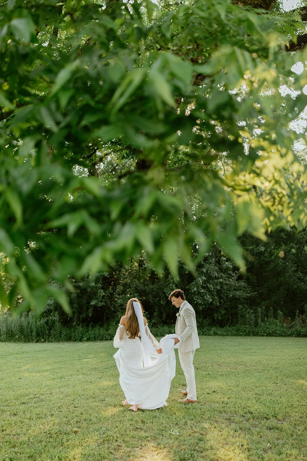 Bride and groom walking hand in hand through a garden on their wedding day