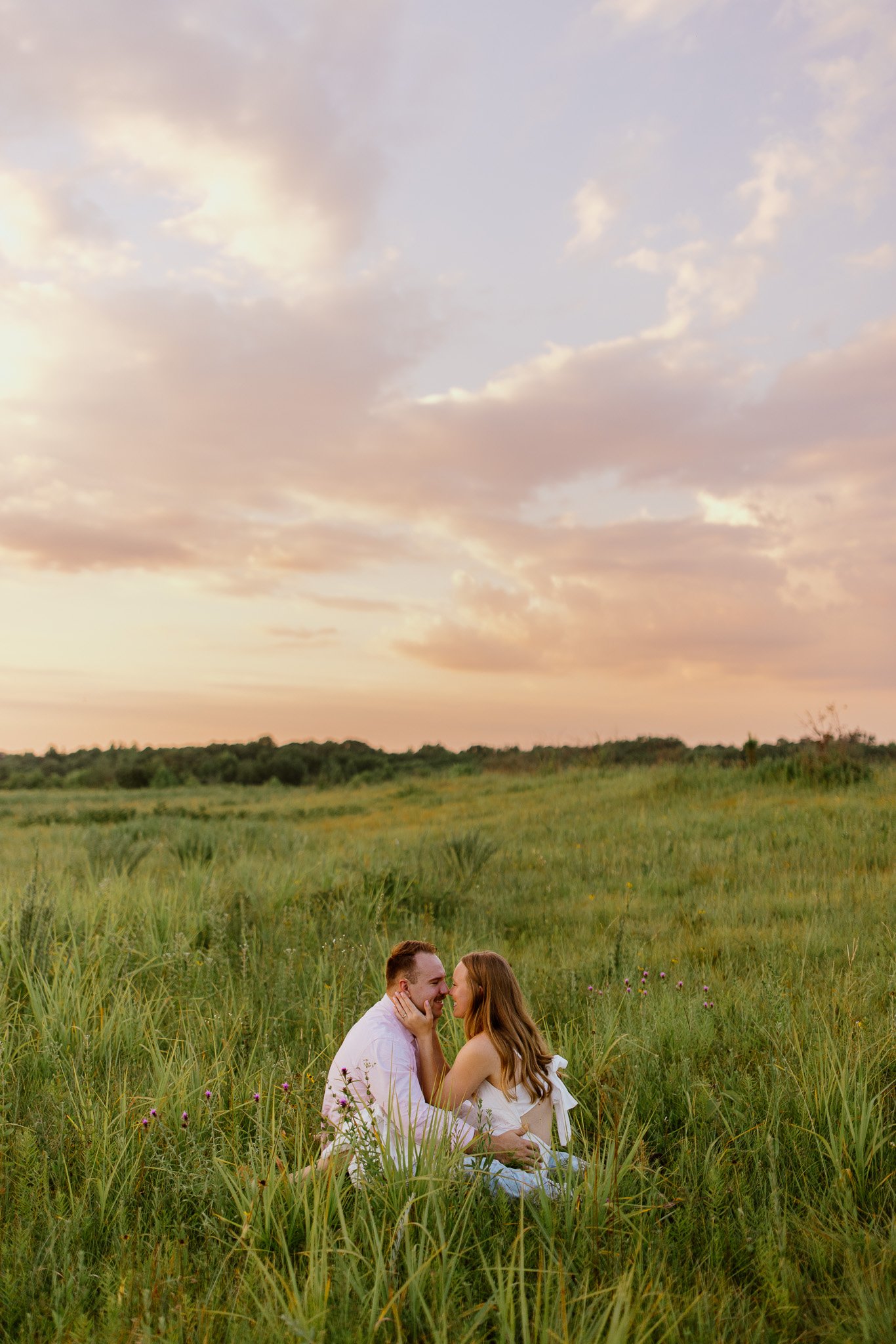 Couple sitting together in a wildflower field at sunset at the Noxubee Wildlife Refuge