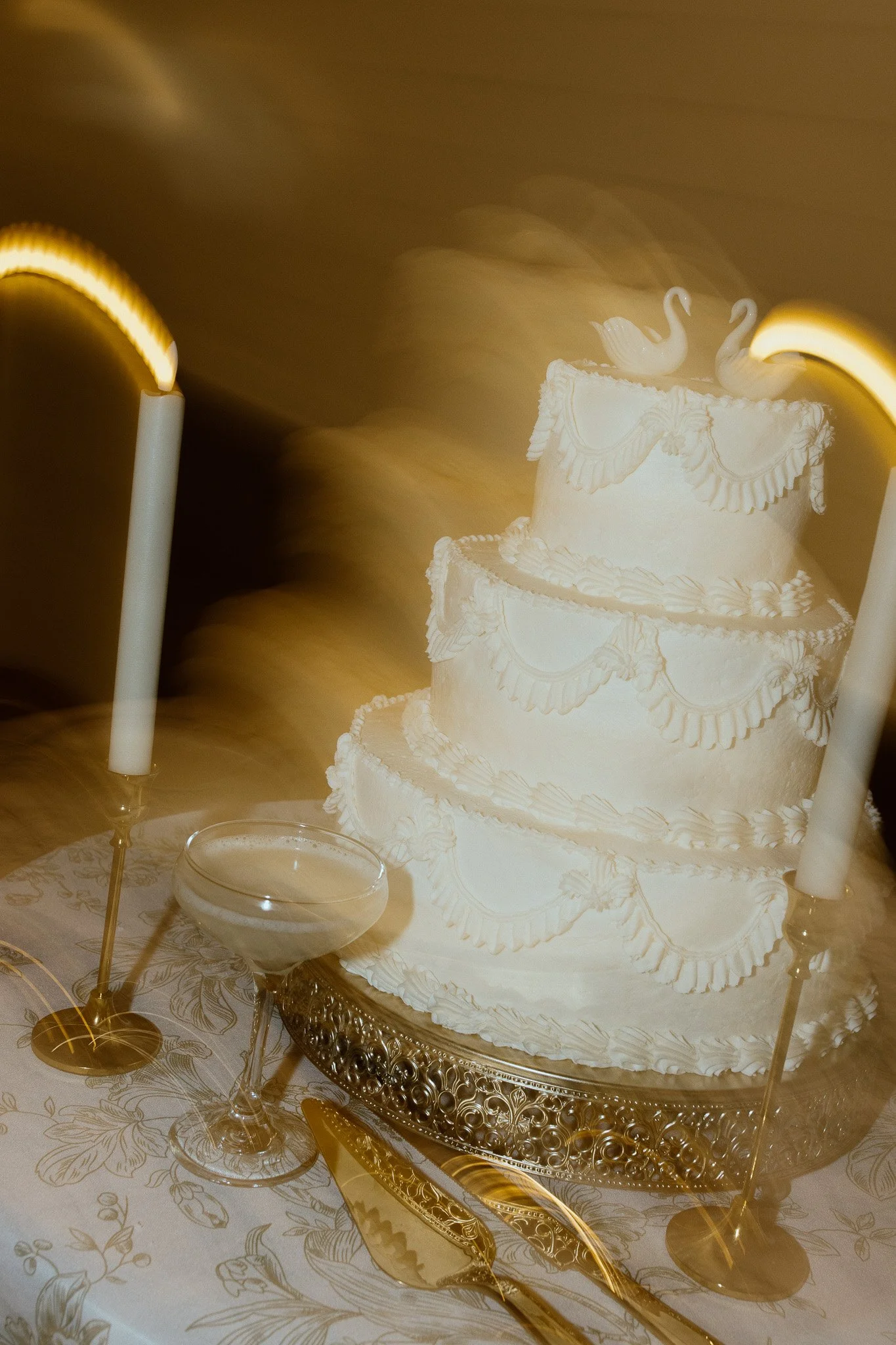 Vintage white wedding cake surrounded by candlelight