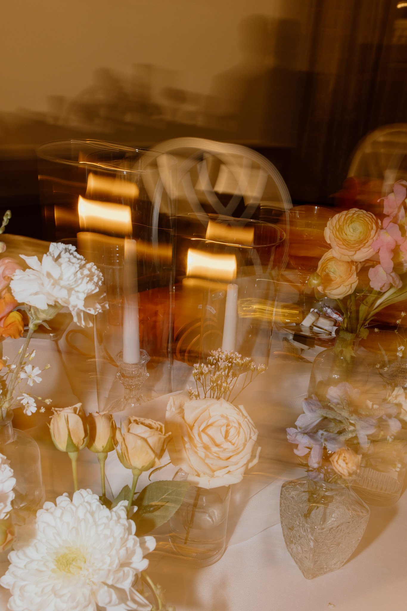Creative motion-blur photograph of wedding flowers and candlelight