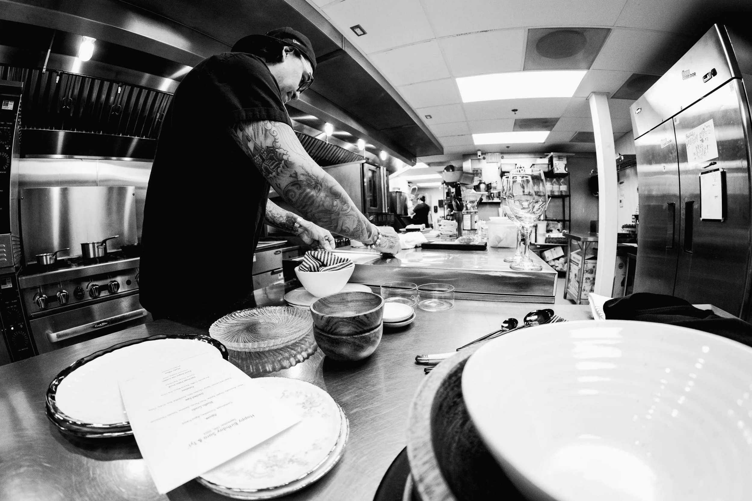Chef Daniel Gaspar in the Daffodil Culinary kitchen, looking at plates and bowls during a custom dinner tasting. Photograoh by Cameron Kisel