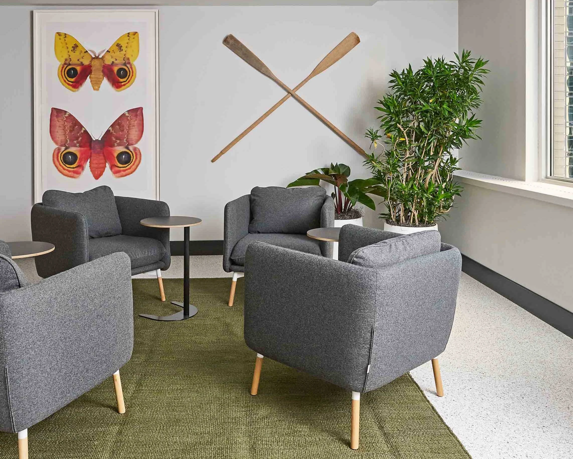 Waiting area with butterfly artwork and modern chairs.