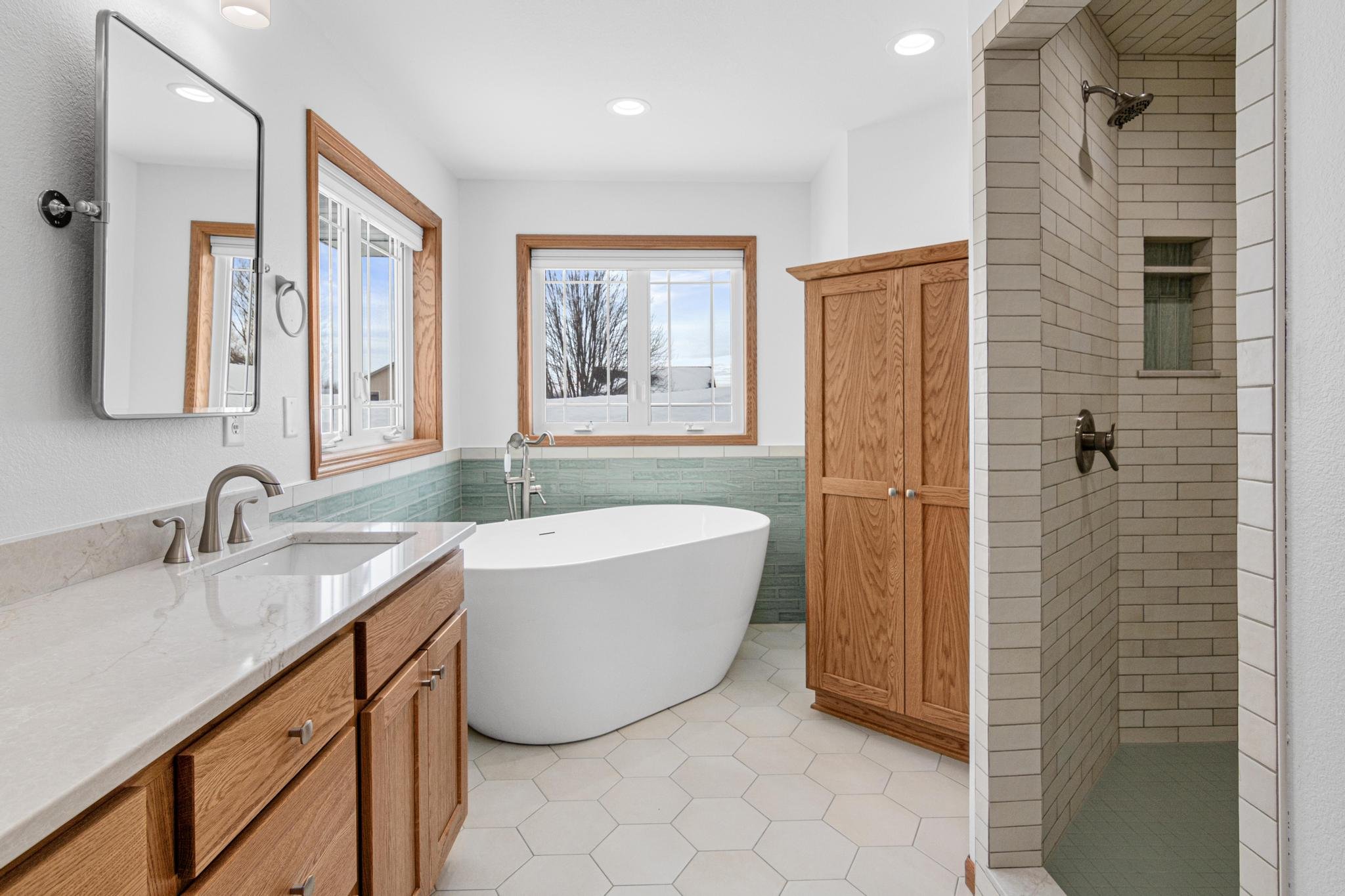 Master bathroom remodel white hex tile freestanding tub custom cabinetry tile shower