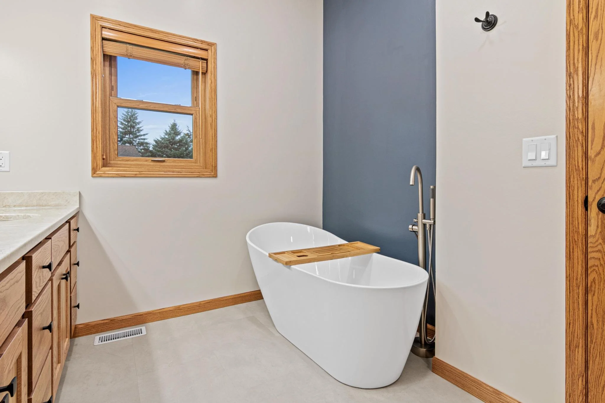 Bathroom Remodel with a freestanding tub quartz countertops and custom golden oak vanity