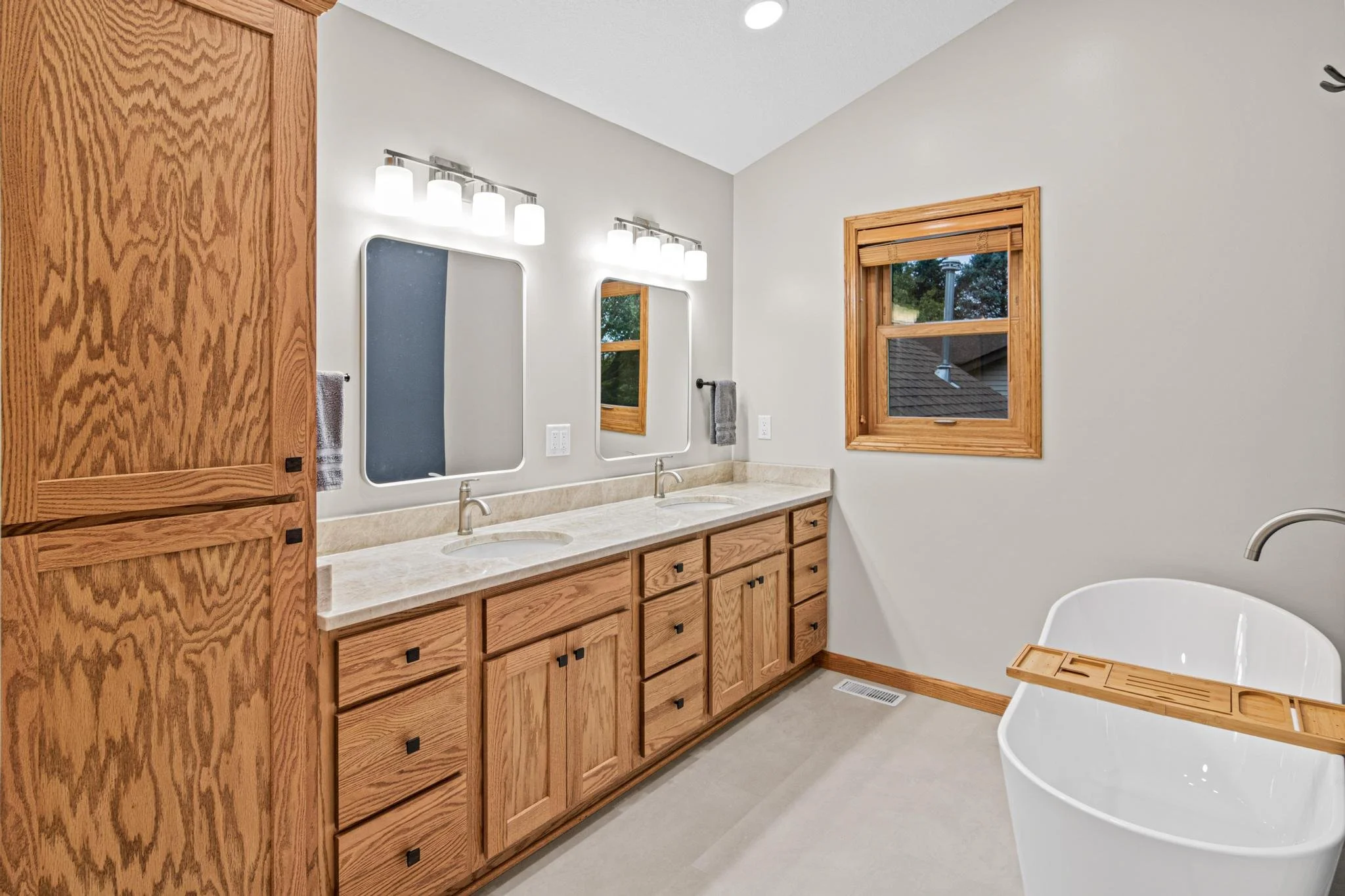 Bathroom Remodel with a freestanding tub quartz countertops and custom golden oak vanity