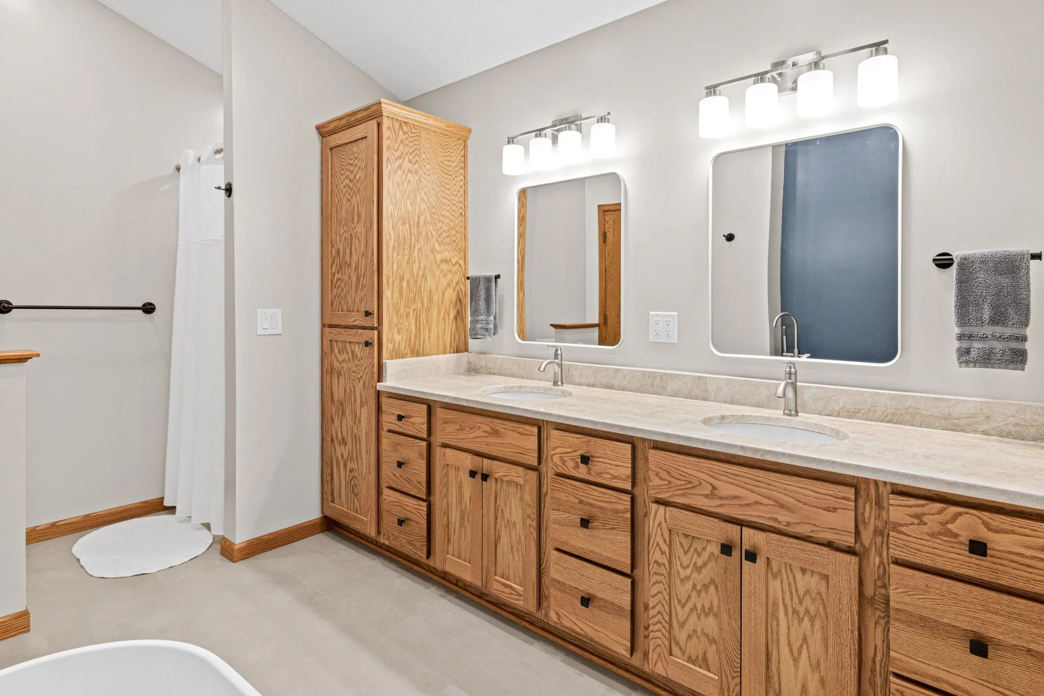 Bathroom Remodel with a freestanding tub quartz countertops and custom golden oak vanity