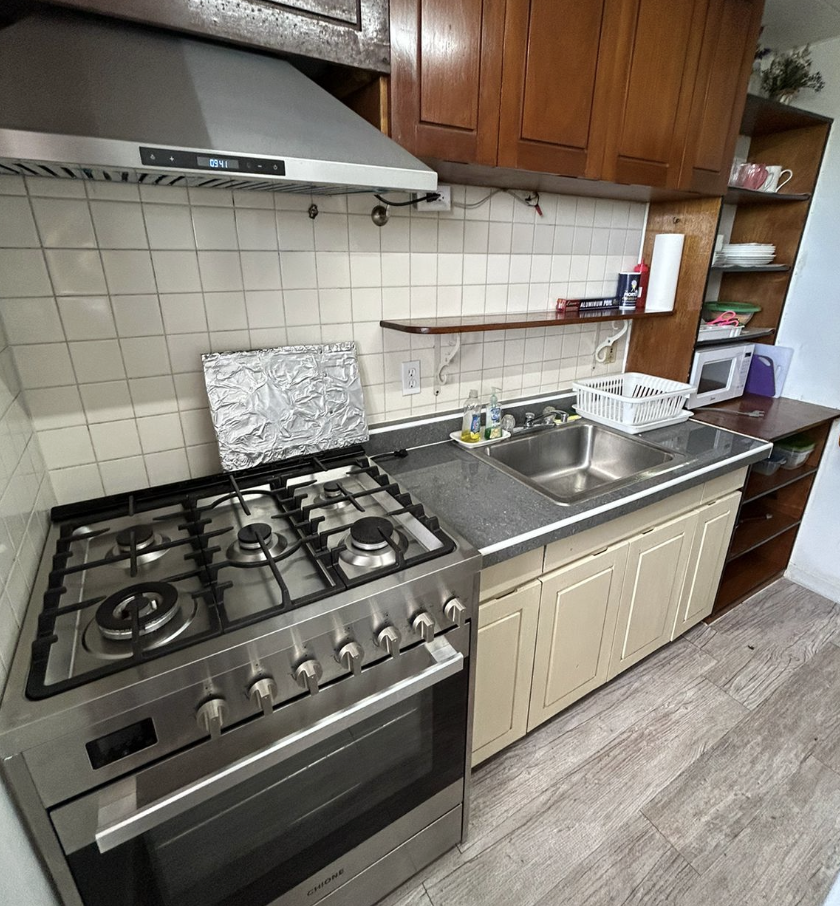 Kitchen with microwave and gas stove with pantry