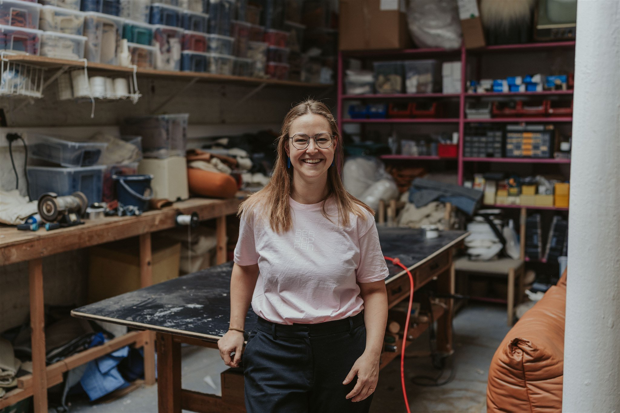 Fien Verheyen standing beside a workbench in the Bea Joppen upholstery workshop.