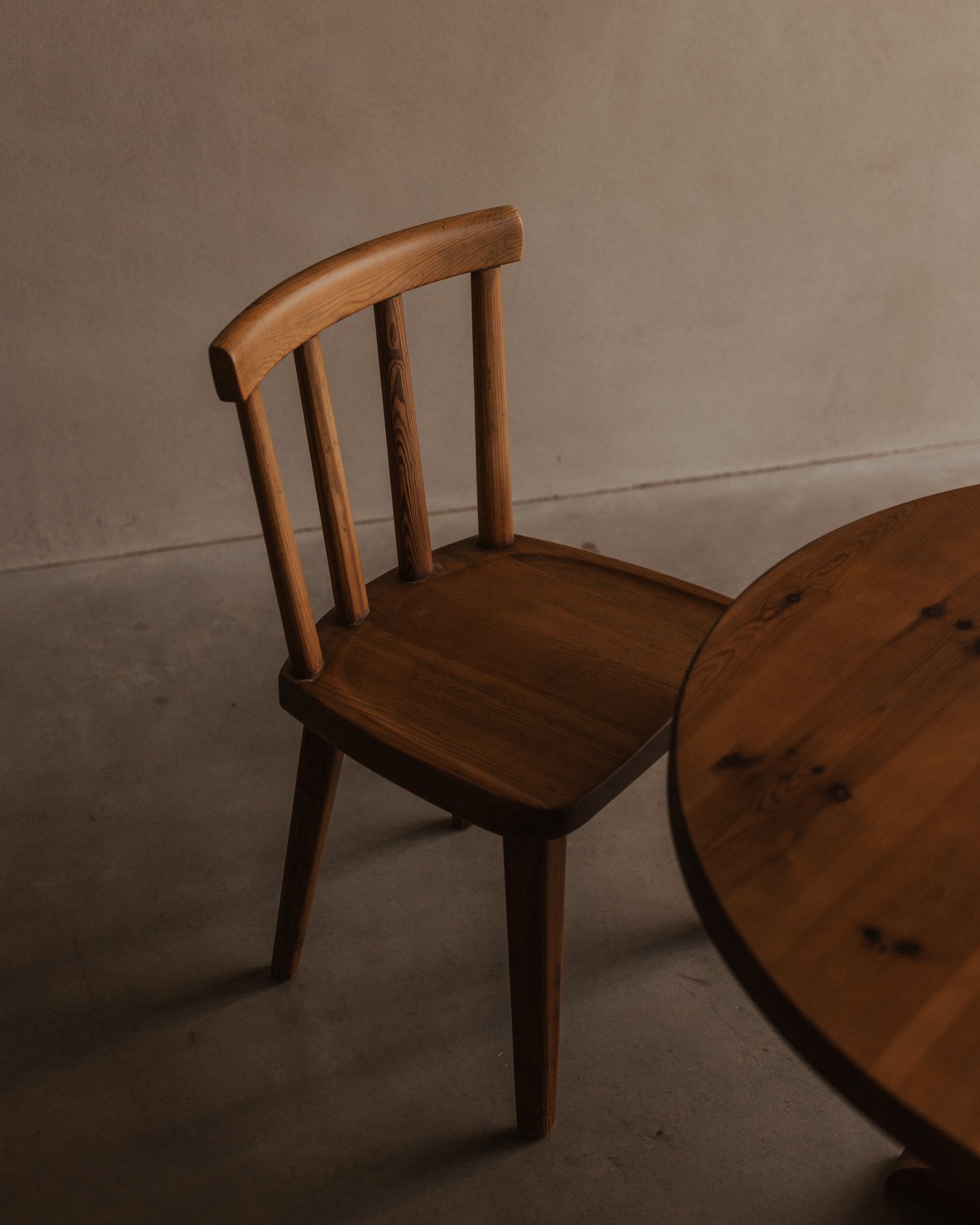 Vintage Swedish stained pine coffee table designed by Axel Einar Hjorth for Nordiska Kompaniet, circa 1930s, with a sculptural three-part base and round tabletop