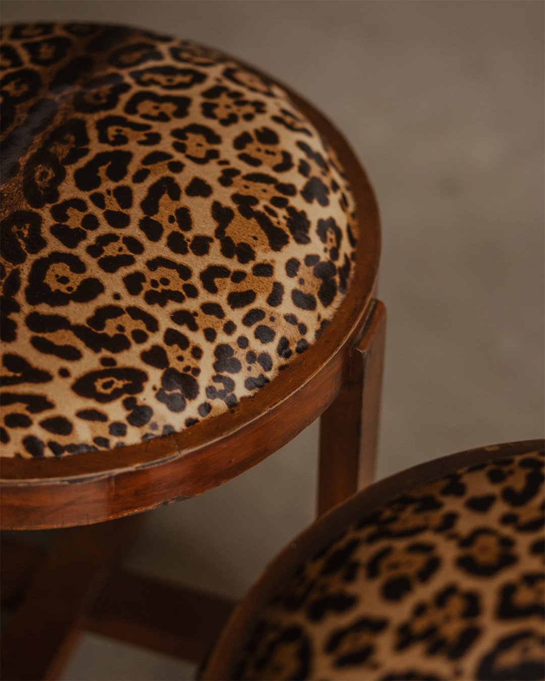 Pair of Art Deco wooden stools with round faux-leopard seats, early 20th century