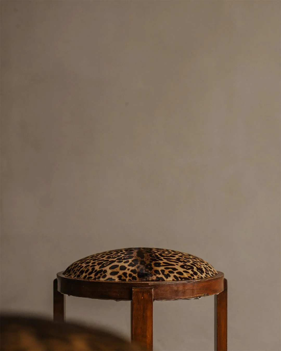 Pair of Art Deco wooden stools with round faux-leopard seats, early 20th century
