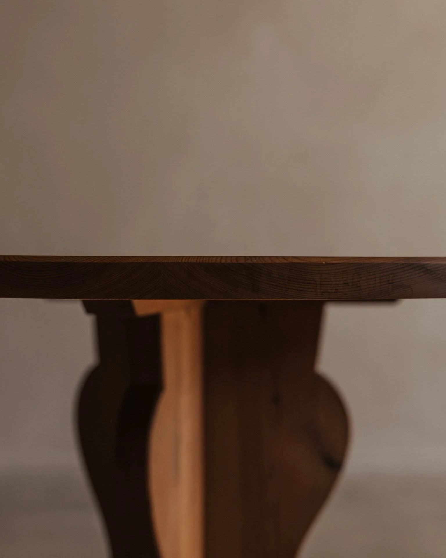 Vintage Swedish stained pine coffee table designed by Axel Einar Hjorth for Nordiska Kompaniet, circa 1930s, with a sculptural three-part base and round tabletop