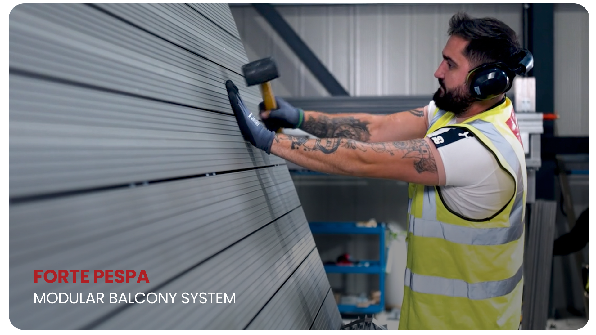 A man wearing a yellow safety vest, white shirt, headphones, and gloves is hammering a panel in a modular balcony system.