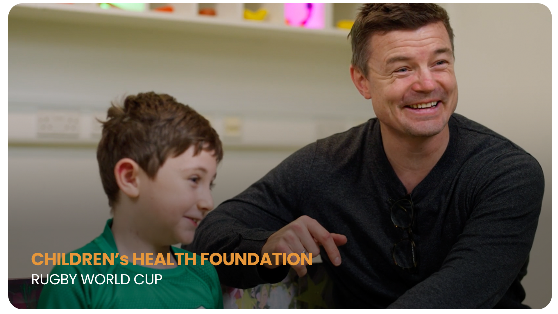 A smiling man and a boy sitting together, with text overlay reading 'Children's Health Foundation Rugby World Cup'.