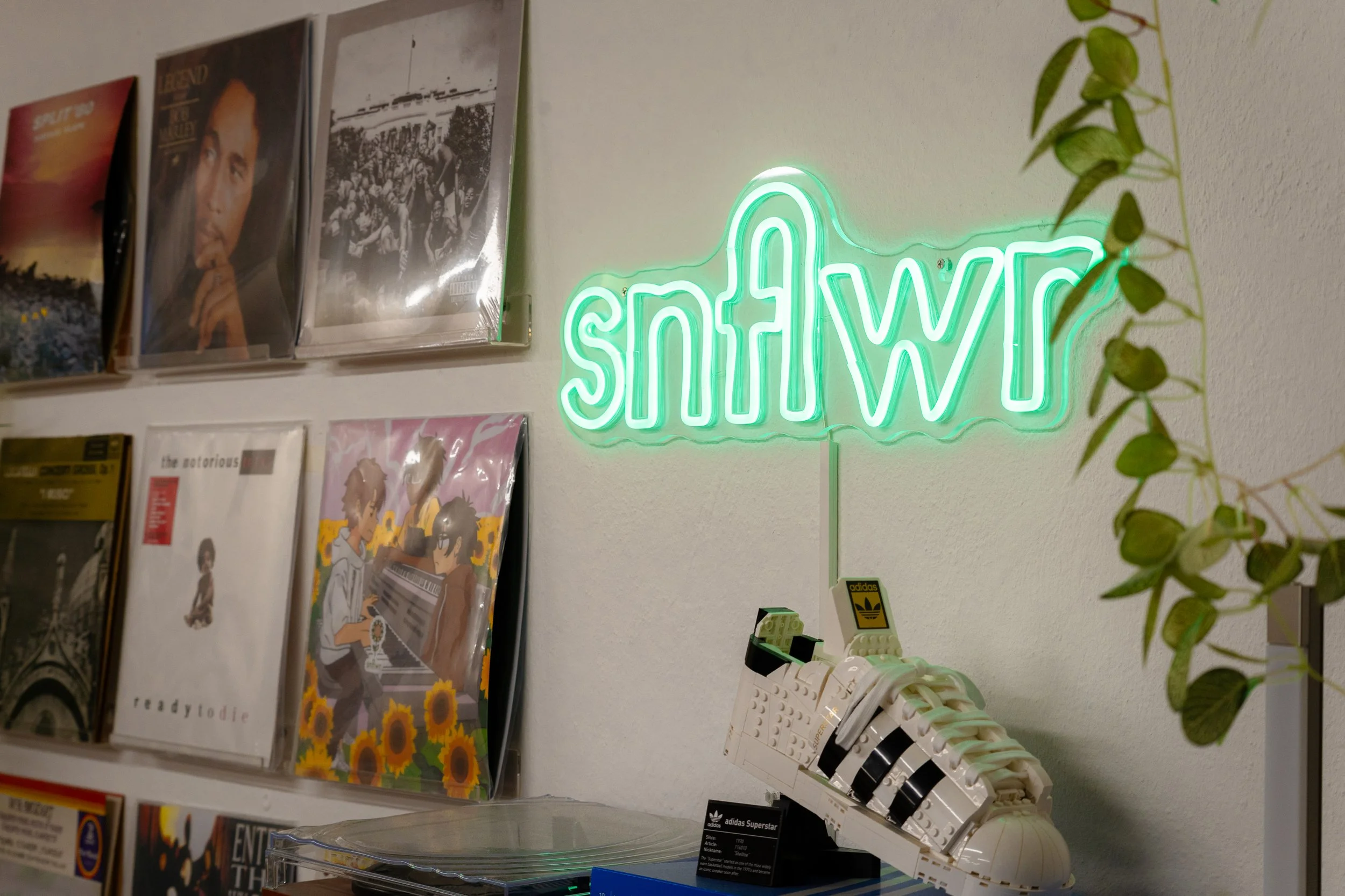 Eine Kameraaufnahme des snflwr Studios in Bern, welches ein Neon-Logo zeigt.
