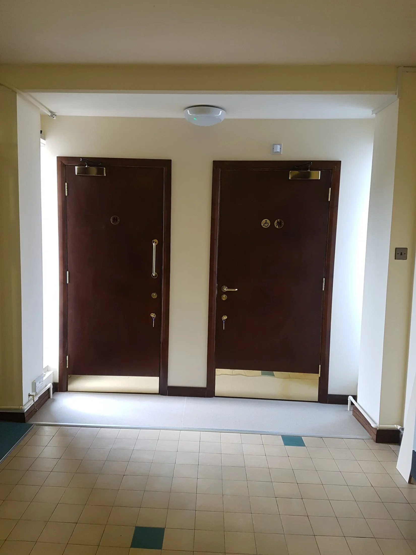 Accessible and standard WC doors at a church in Poole