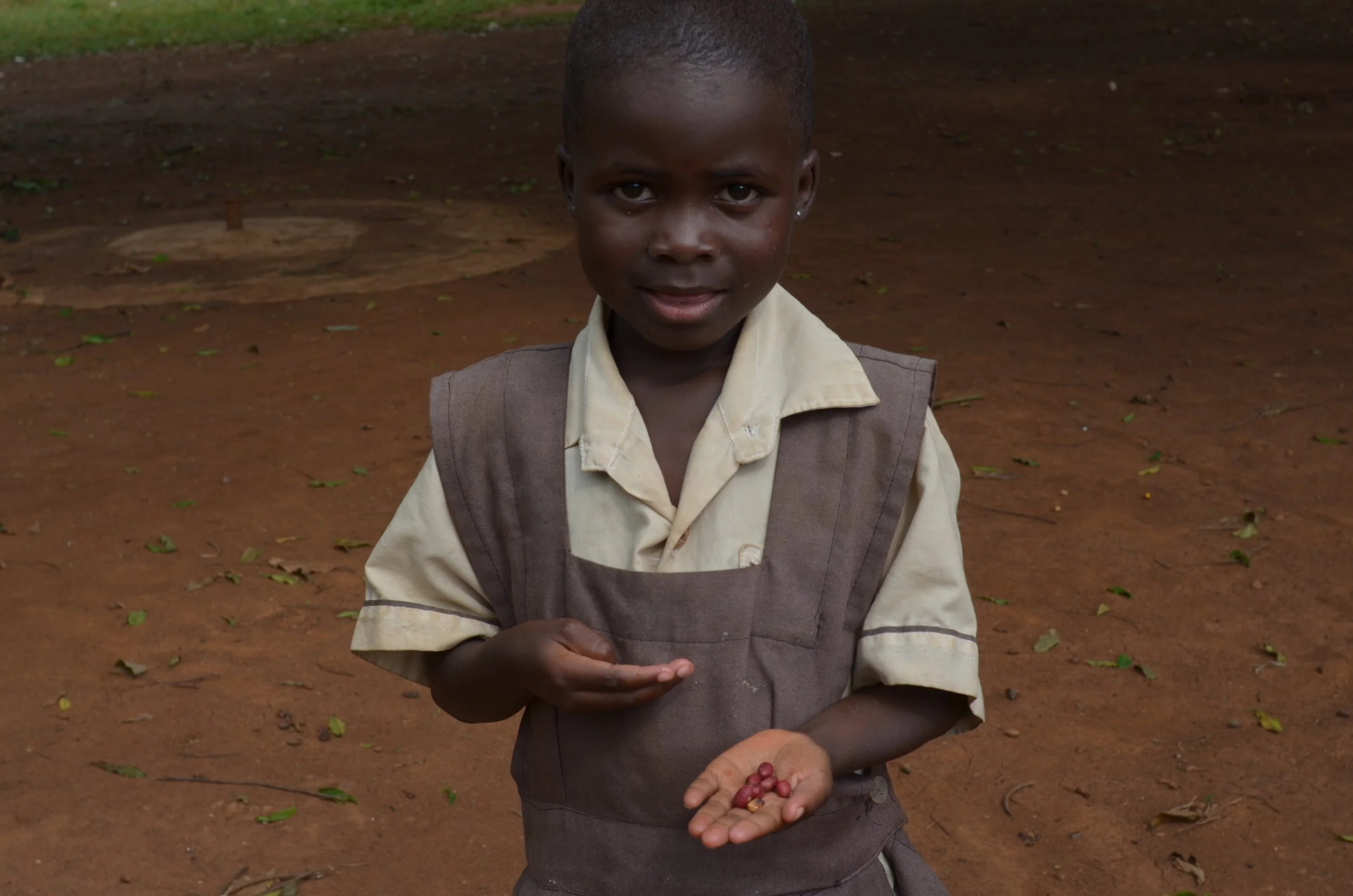 A young student from Nyamwanga, a school sponsored by The Boo Charity, holding a handful of peanuts.