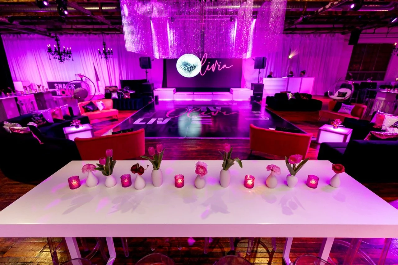 The Boathouse at The Knowlton transforms into a high-energy Bat Mitzvah celebration space with a custom dance floor, dramatic pink uplighting, crystal chandeliers, and personalized LED screen design for the guest of honor. Lounge seating and layered 