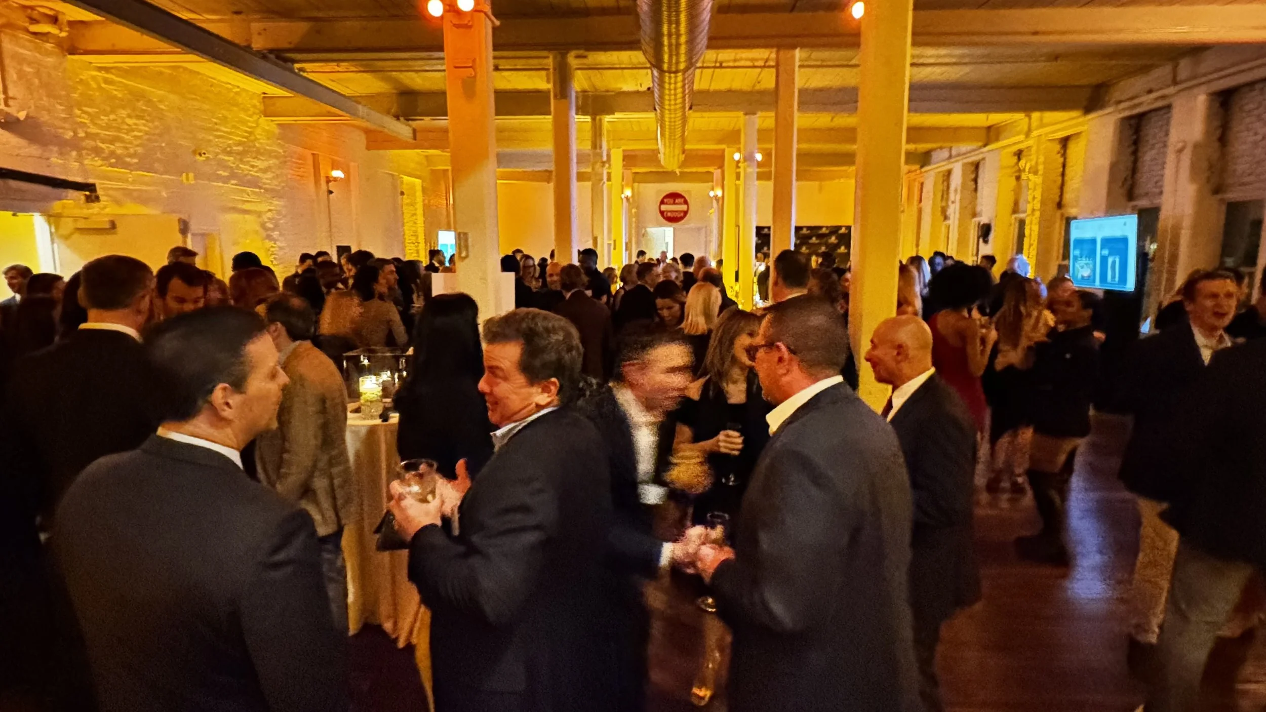 Elegant cocktail event in the Wilder Gallery at The Knowlton, featuring a modern bar setup, ambient lighting, and a sophisticated atmosphere ideal for corporate gatherings and networking events.