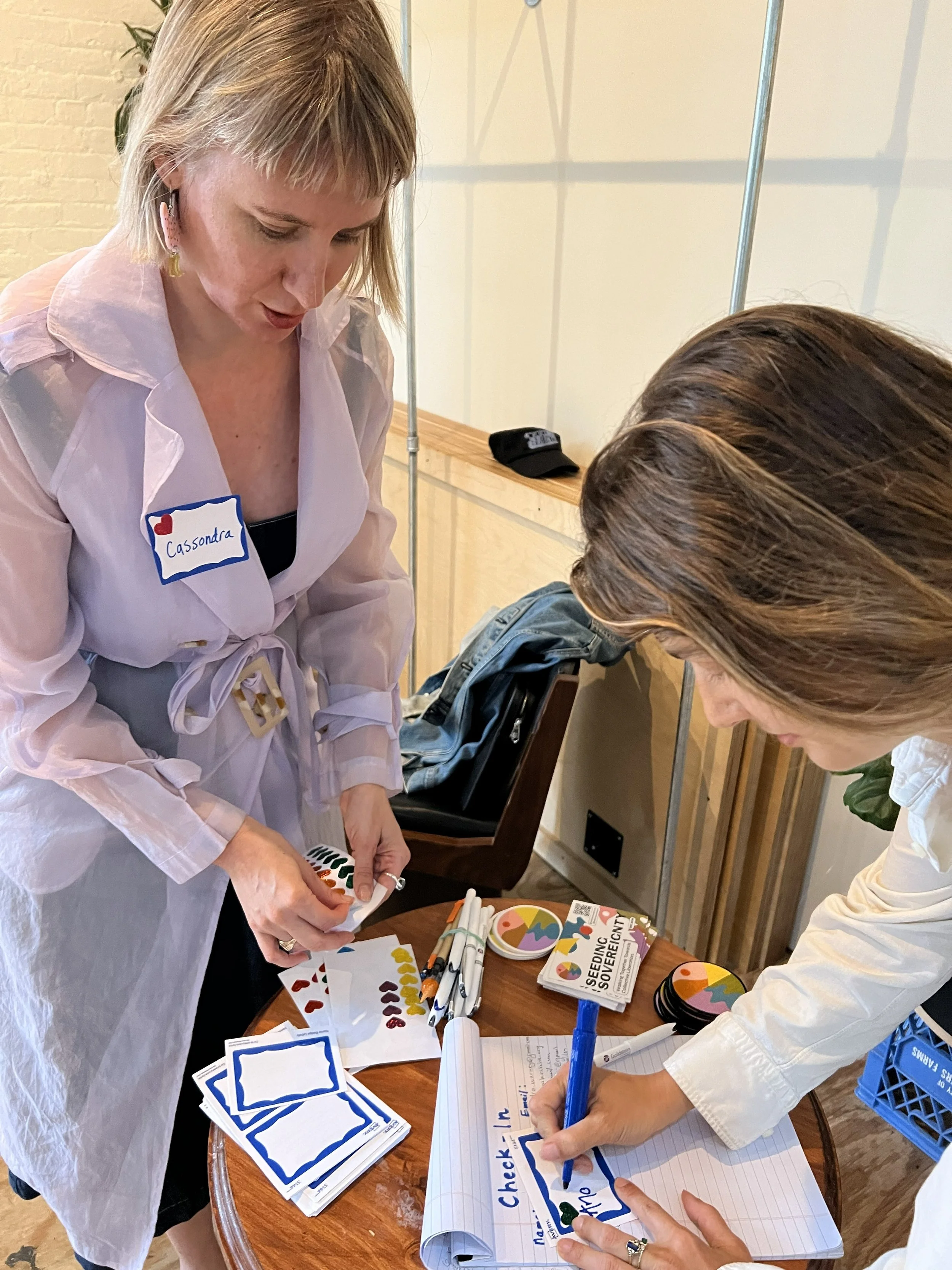 Two people filling out a sign up form for an event.