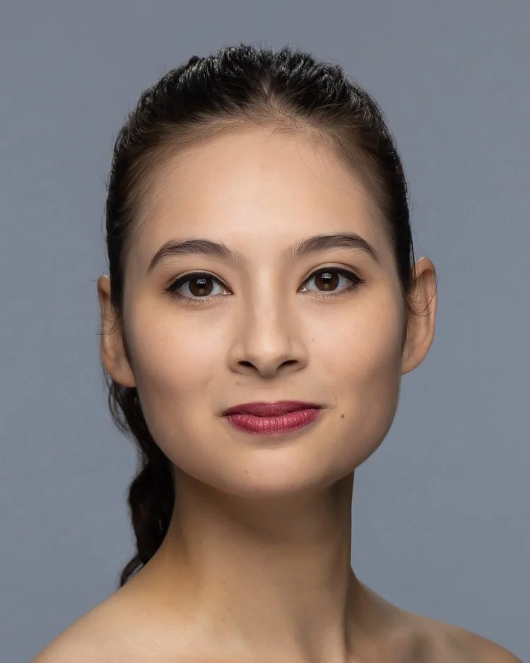 A striking photo  of a dark haired dancer looking directly at the camera.