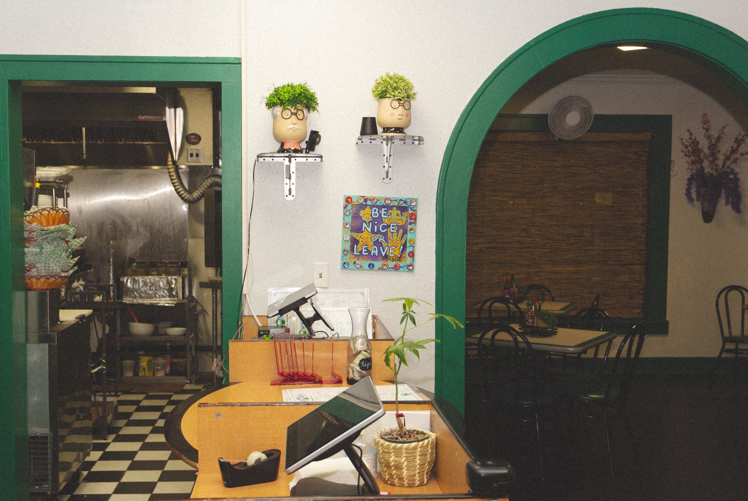Photograph of Pham's dining room featuring clean white walls with green accents.
