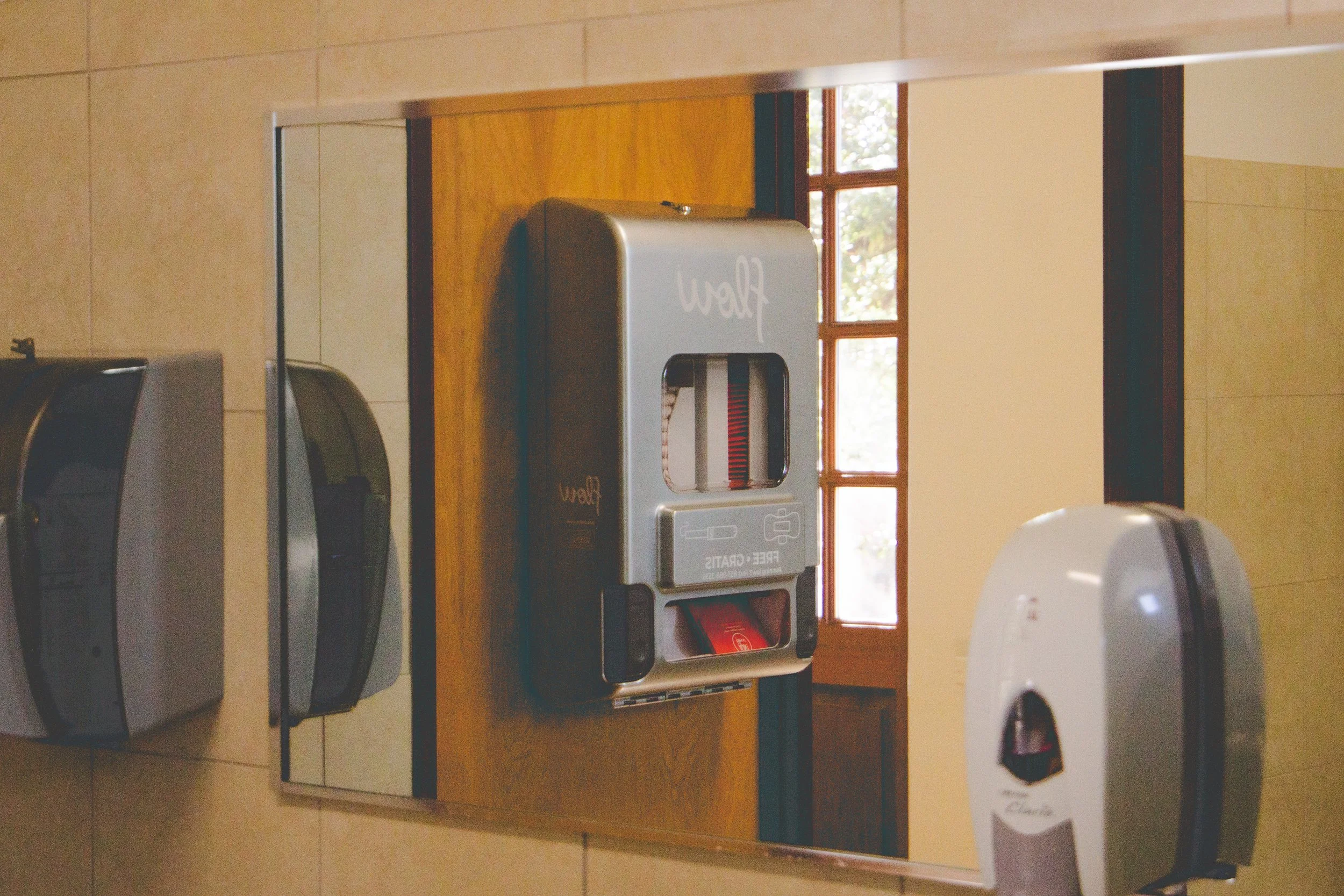 Mirrored photograph of tampon dispenser.