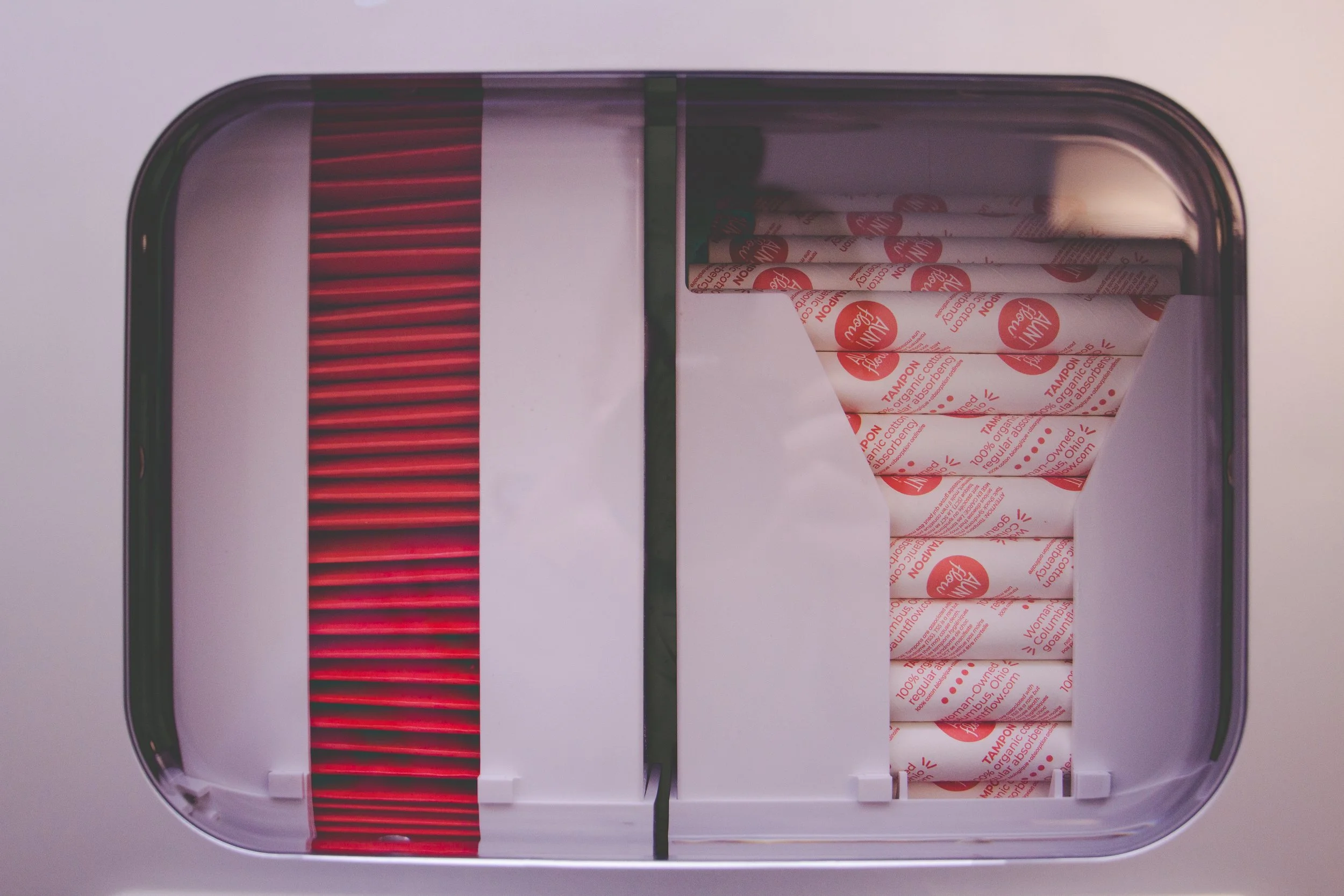 Stylized photo of pad and tampon dispenser.