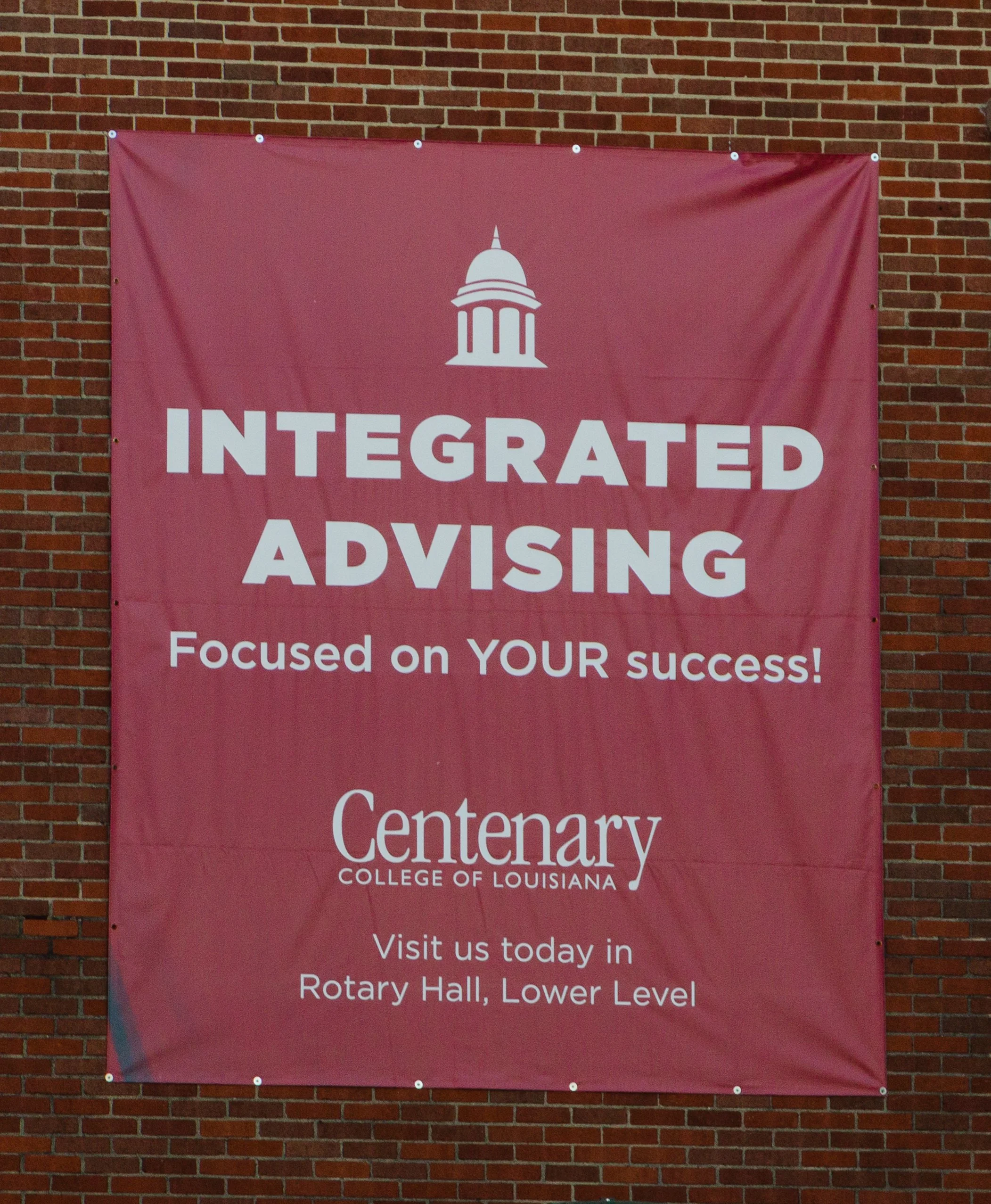 Banner tacked to brick stating, "INTEGRATED ADVISING: Focused on YOUR success!"