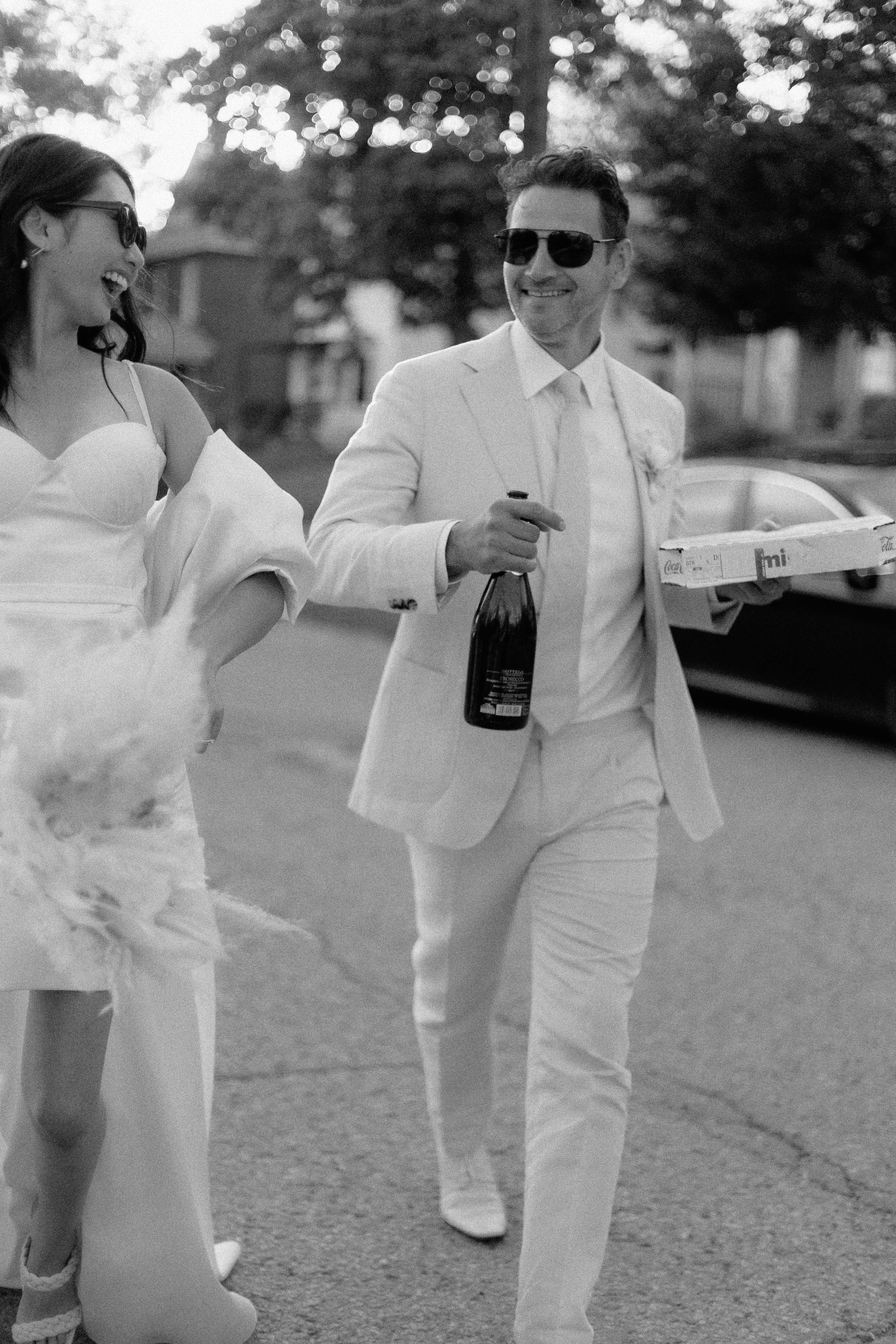 bride and groom walking and drinking champagne after celebrating their elopement