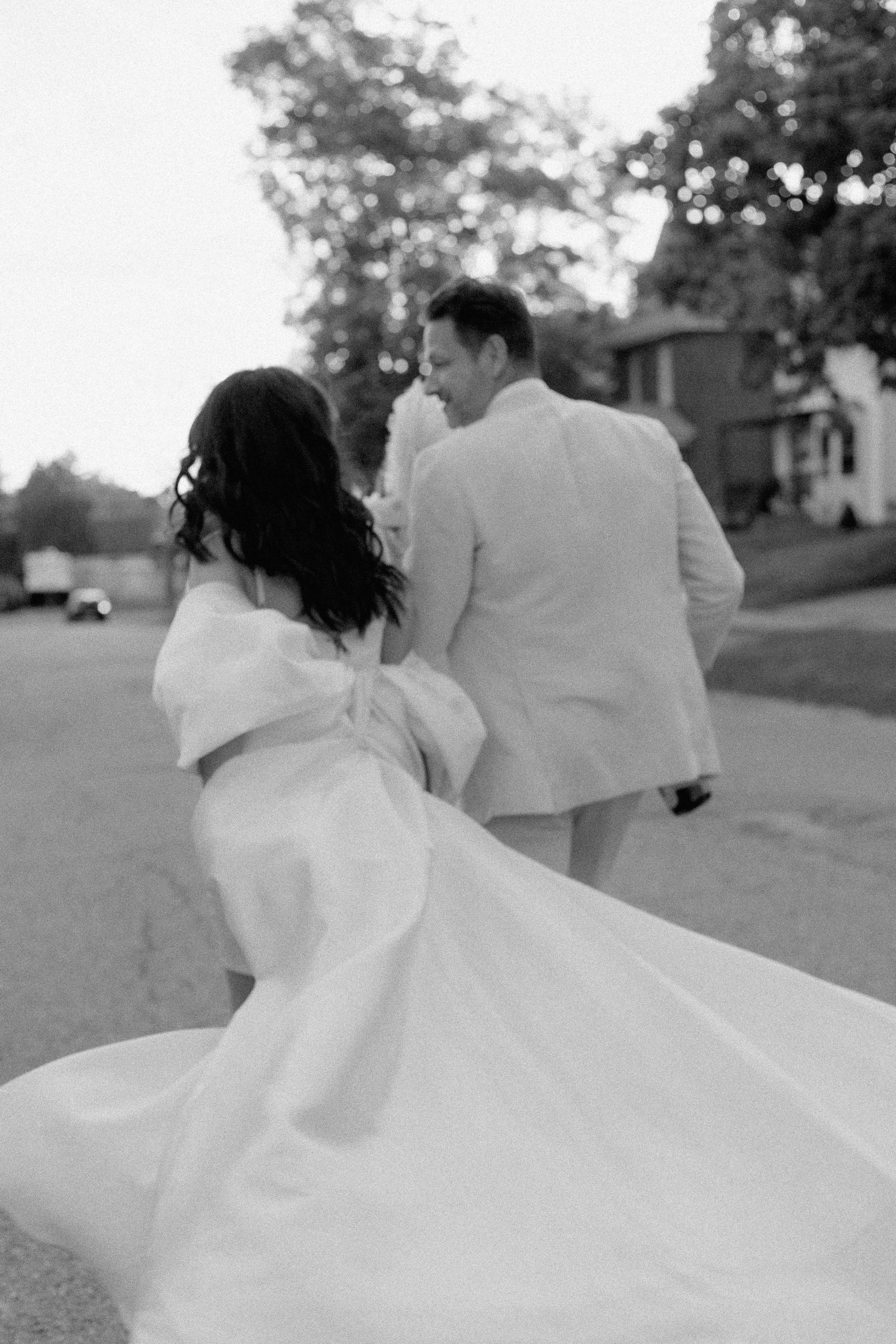 bride and groom walking down road while walking down the road