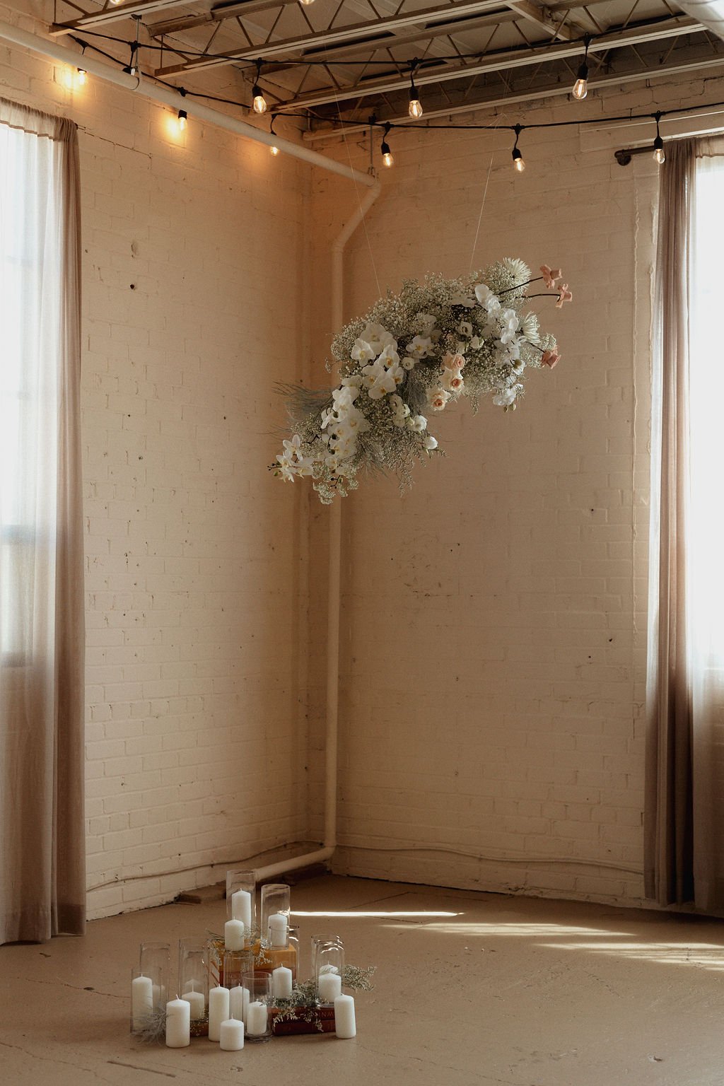 gorgeous stand alone flower arch with candles lit underneath the arch for bridal portraits
