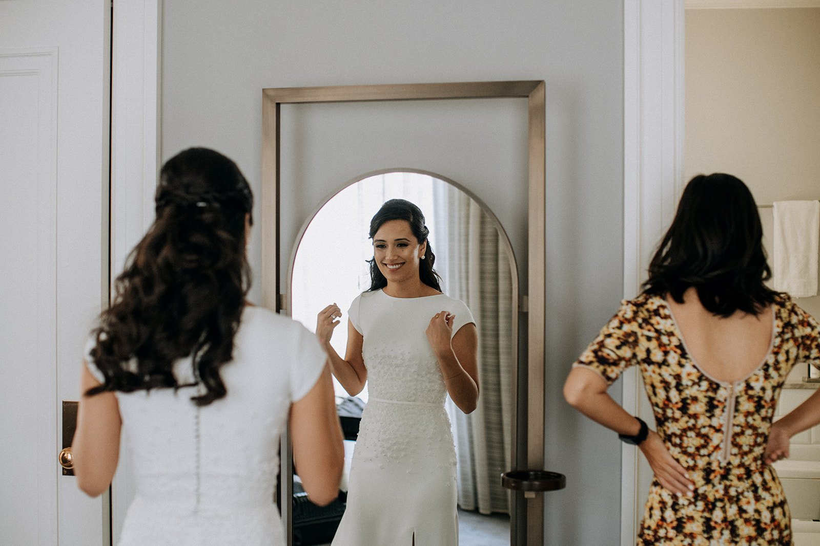  bride looking at herself in a mirror  