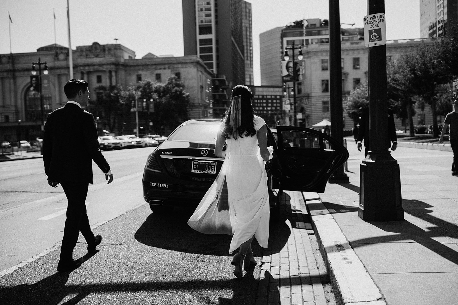  bride and groom walking towards a car together in black and white  