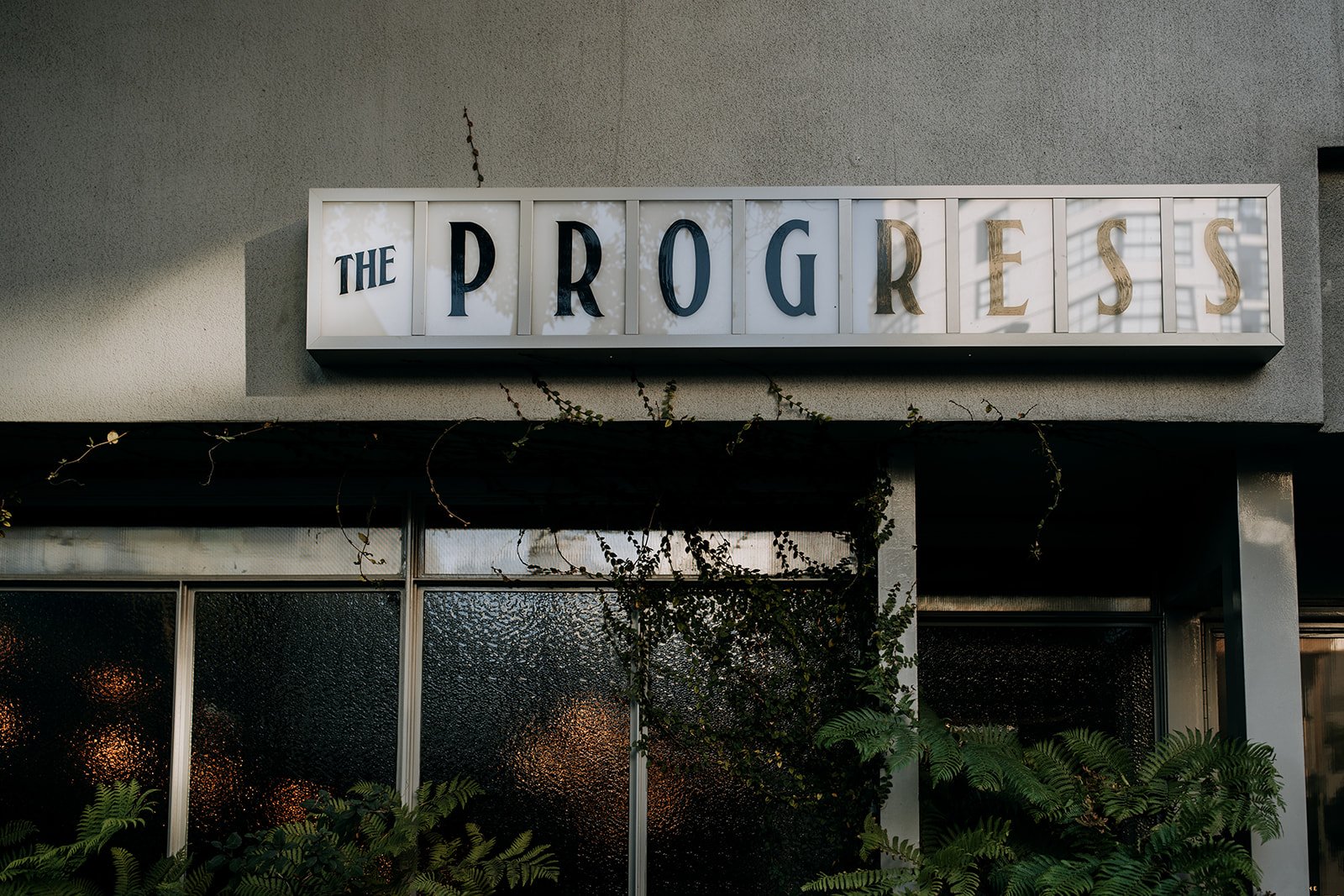 outside of a city building with sign that reads the progress 