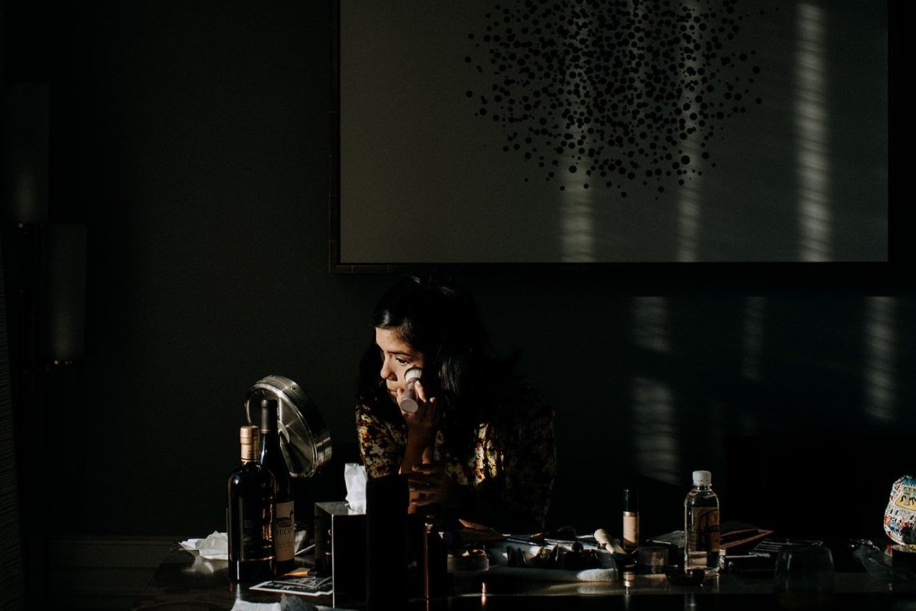  woman doing her makeup in a mirror 