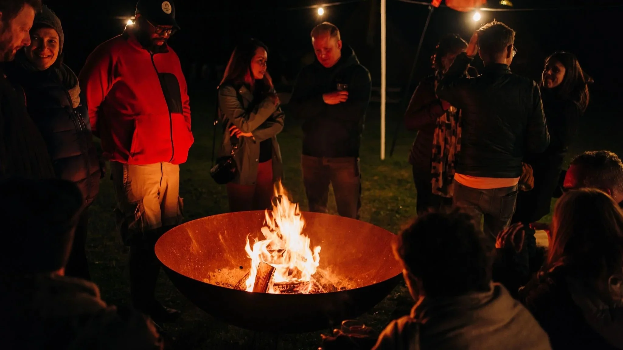 Founders gathered around a fire at Happy Startup School Summercamp