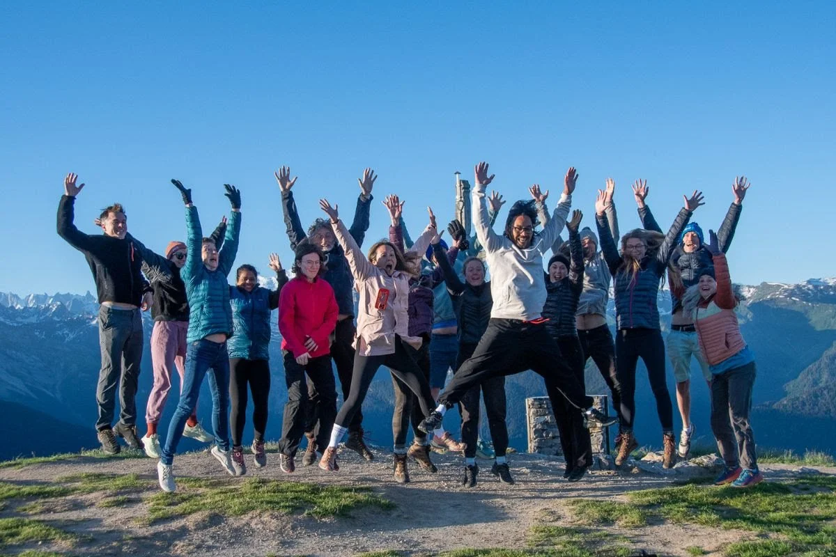 Entrepreneurs jumping for joy at a mountain retreat
