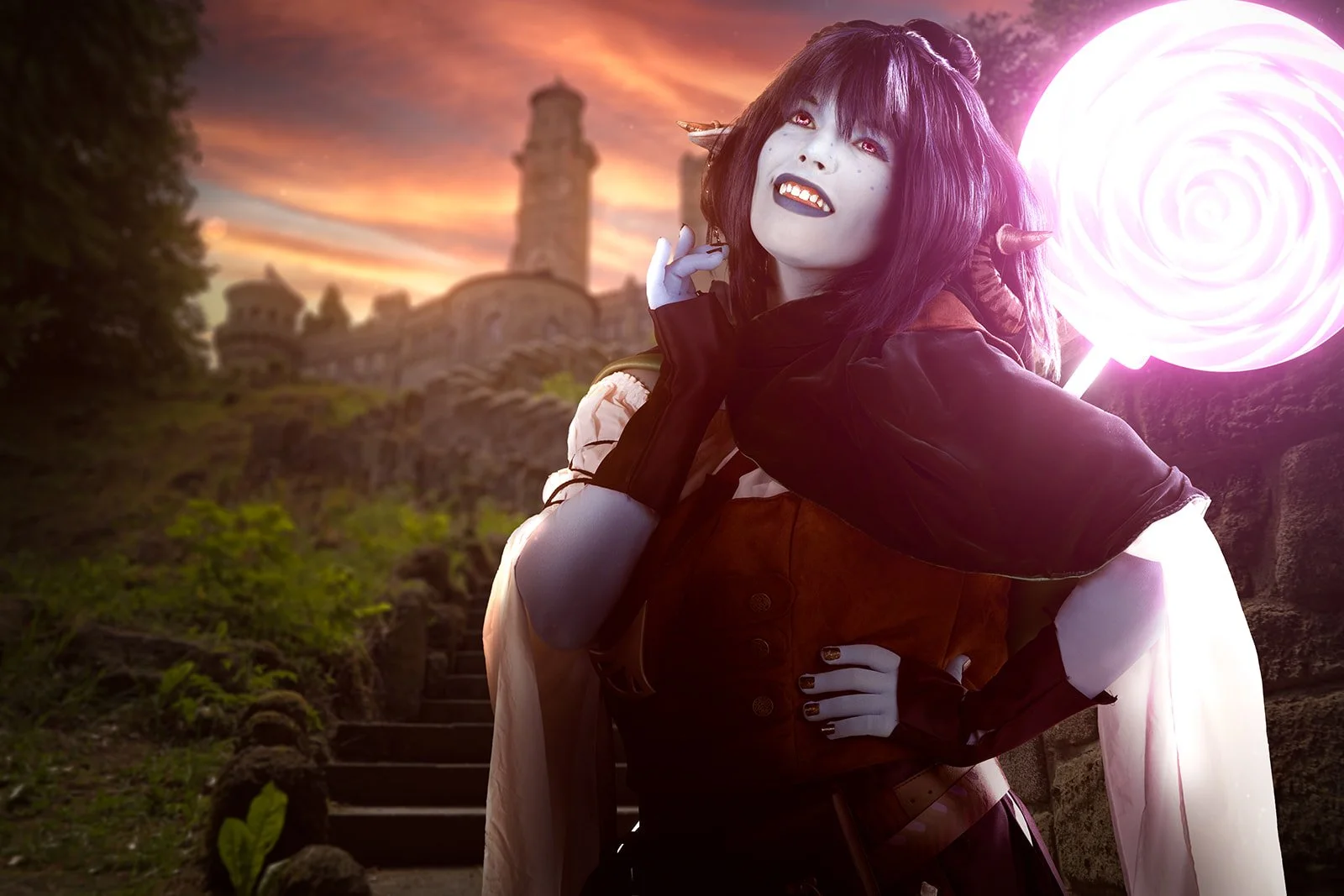 A portrait of a woman cosplaying as Jester Lavorre, wearing a thoughtful and smiling expression. She carries a large glowing pink lollipop on her back. In the background, there is a castle surrounded by stone steps, set against a fantasy-like landsca