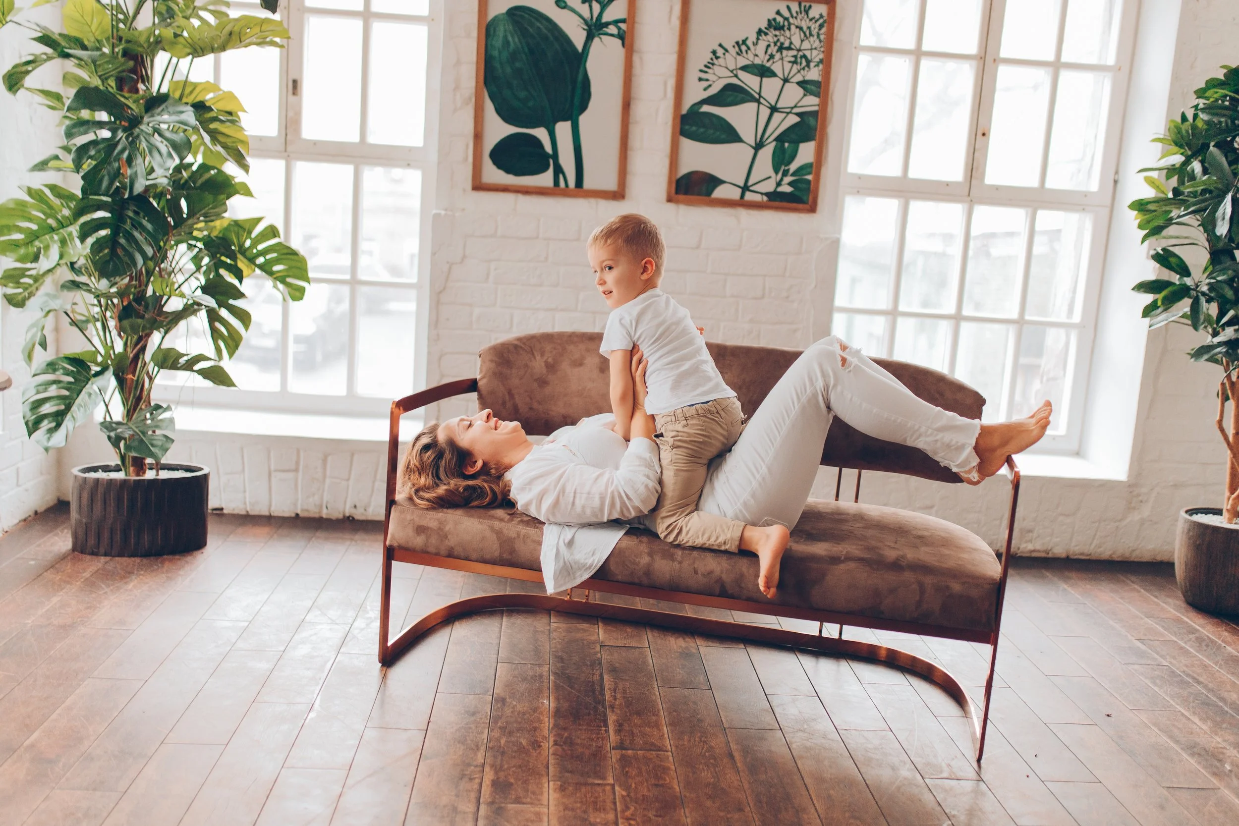 mother-and-little-boy-are-playing-together-on-a-couch-in-a-light-room-with-green-plants_t20_kz8AmR.jpg