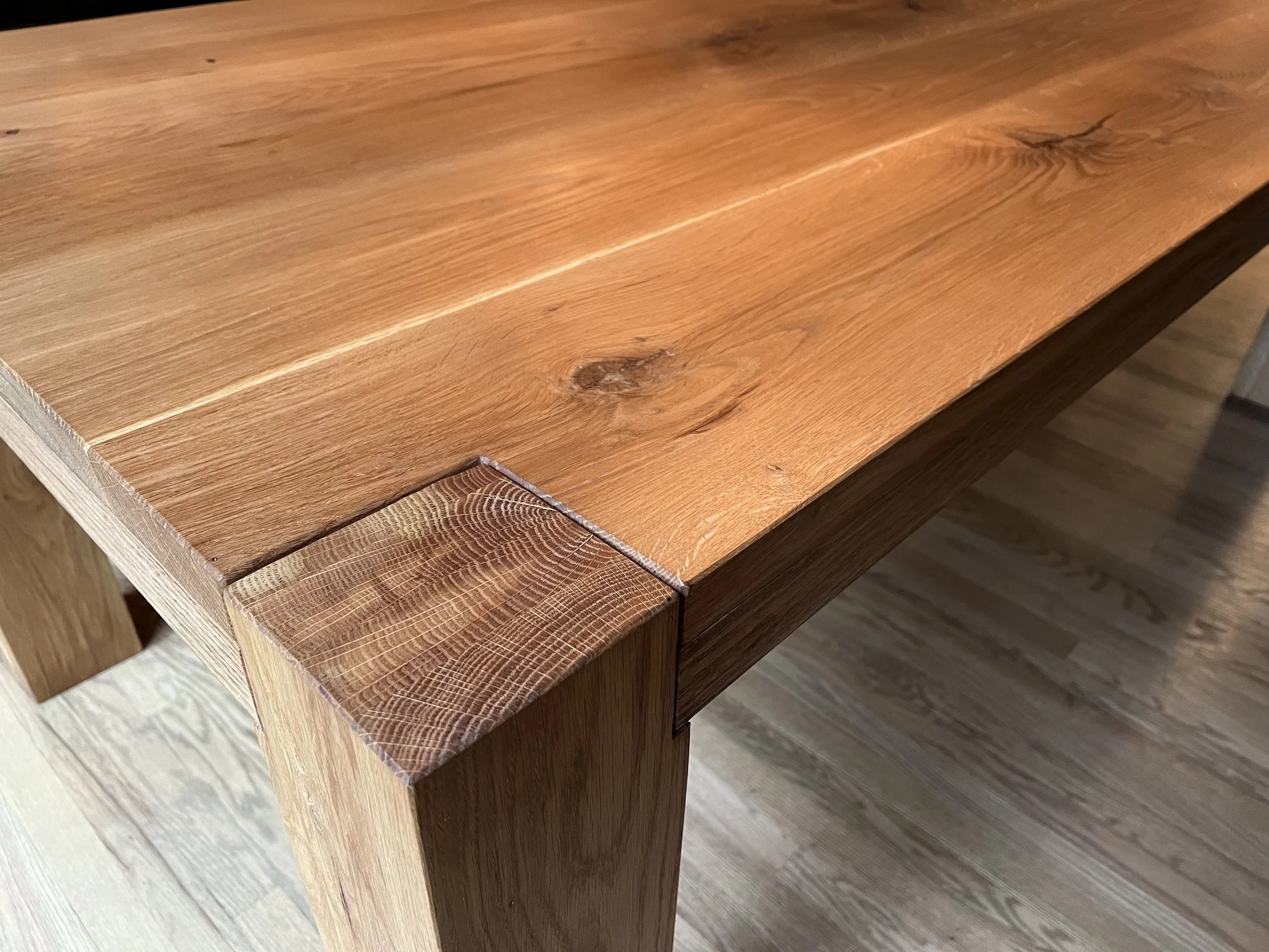 Close-up of a wooden table corner showing detailed grain and a natural finish.